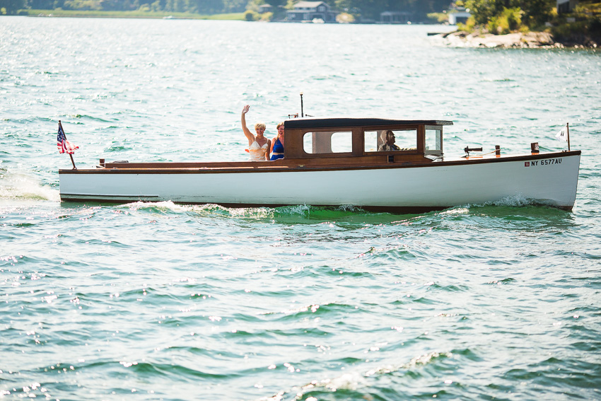 bride arriving to thousand islands wedding on antique boat