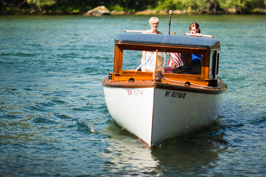 bride arriving to wedding in a thousand islands antique boat