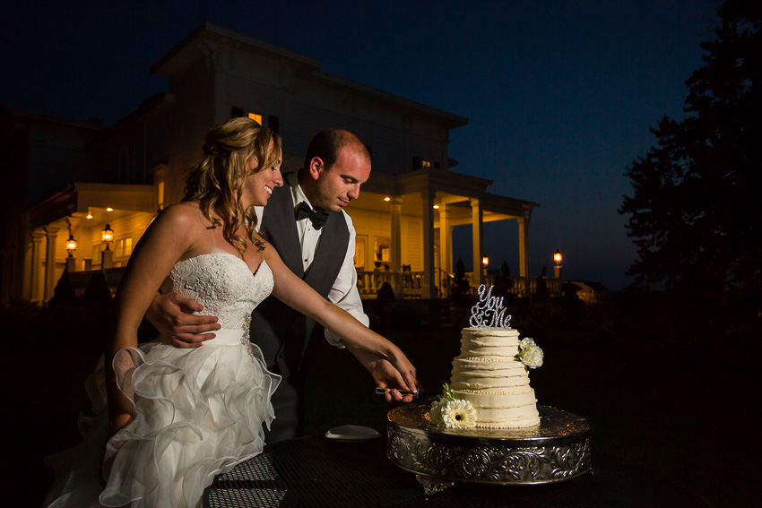 cutting the cake in front of John Joseph Inn at night