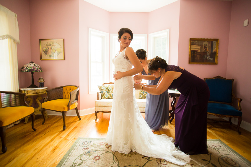 bride getting dress on before wedding