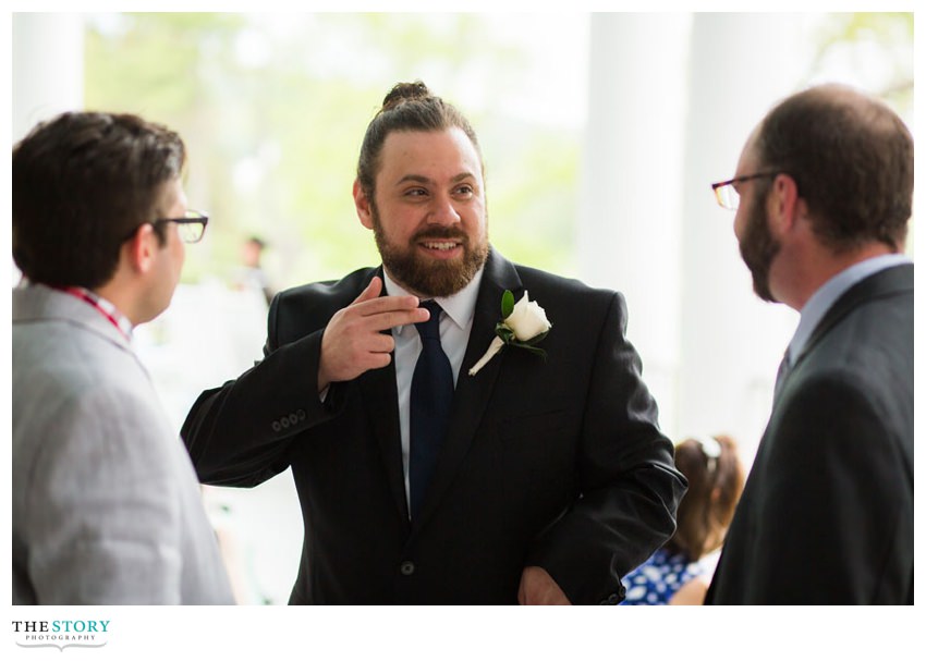 groom telling a story during the cocktail hour on the veranda at Otesaga