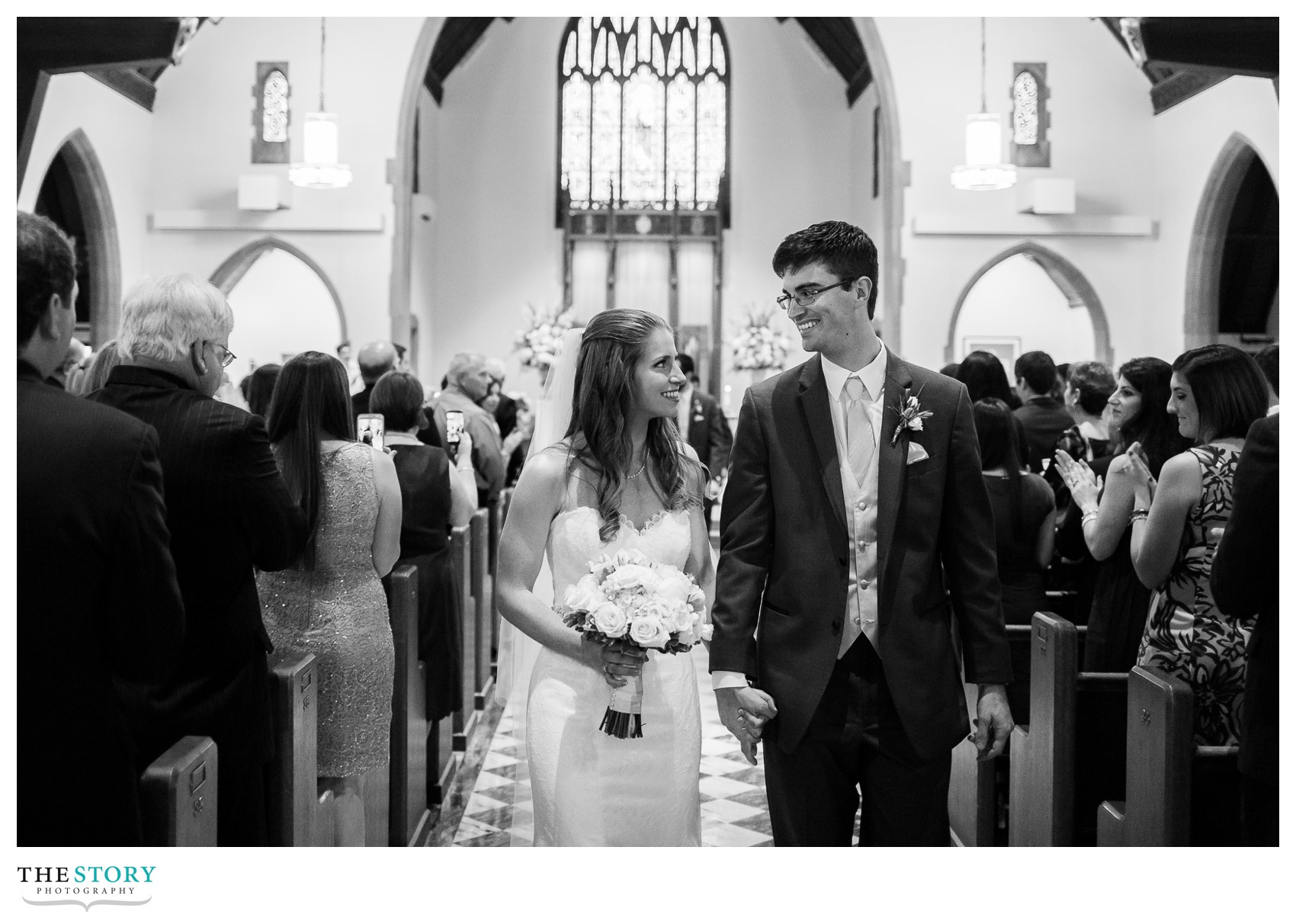 bride and groom leaving Nazareth College Linehan Chapel wedding