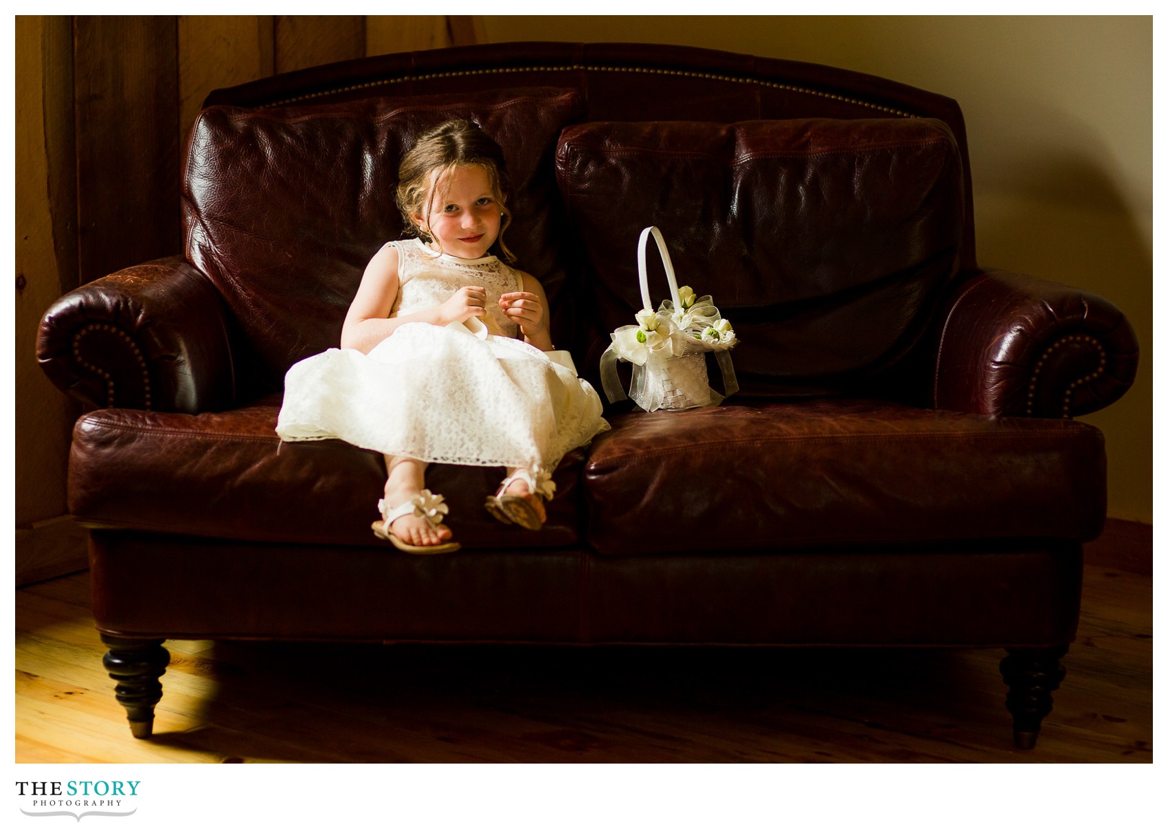 flower girl resting on couch at Wolf Oak Acres wedding