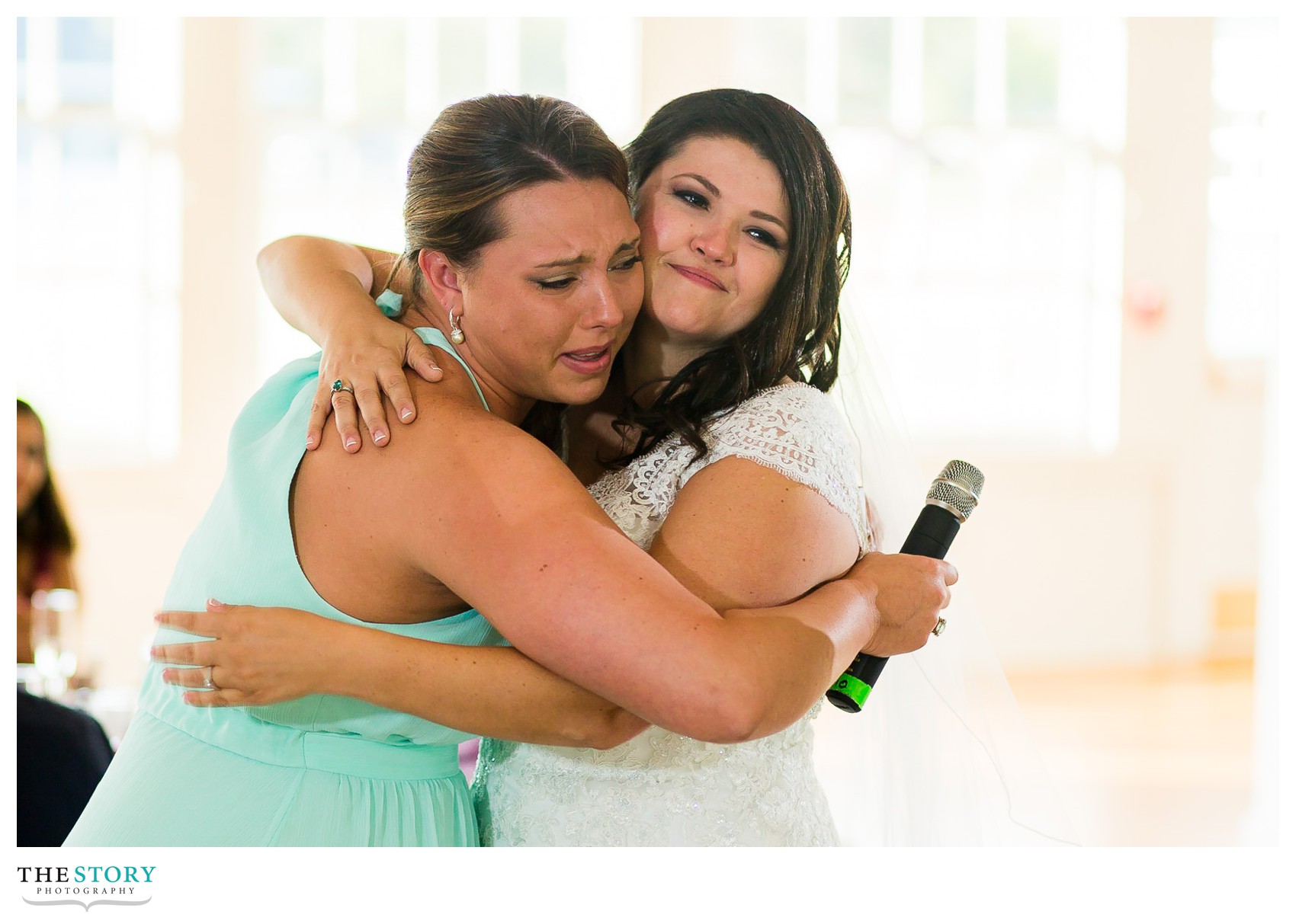 bride and maid of honor hug at Auburn, NY wedding reception