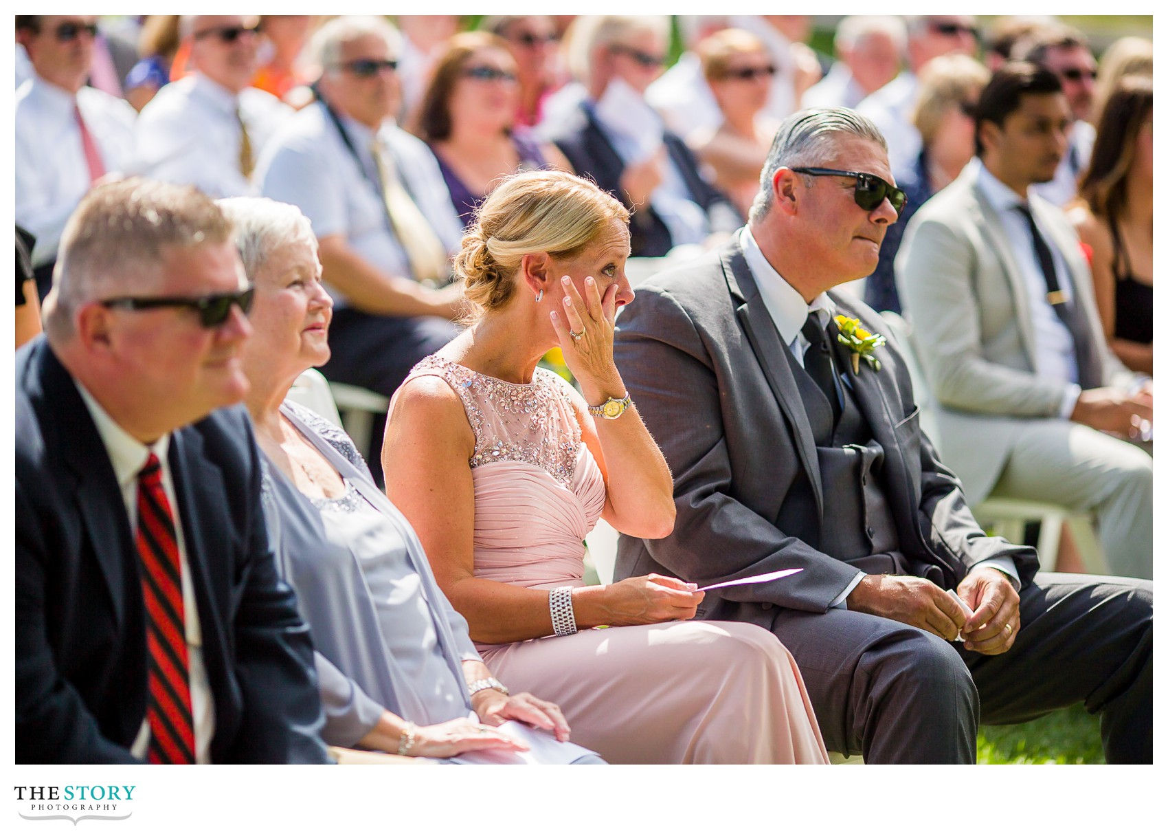 groom's mom wipes tears at Wellesley Island wedding ceremony