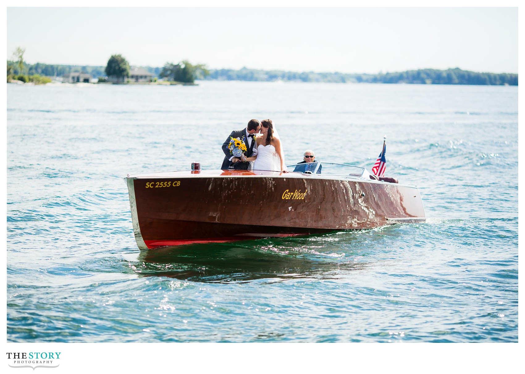 bride and groom greet guests on antique boat from Wellesley Island
