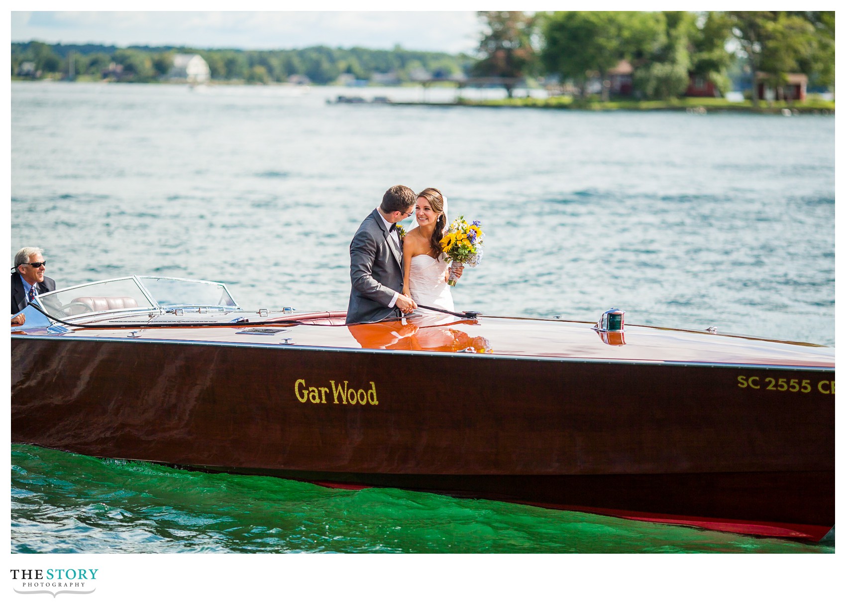 bride and groom take antique boat ride on the St. Lawrence river after wedding ceremony