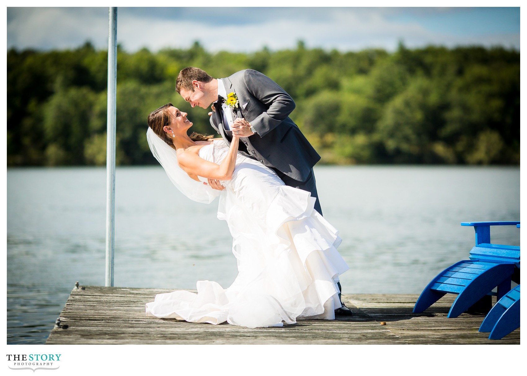 groom dips bride on St. Lawrence river dock for wedding photos
