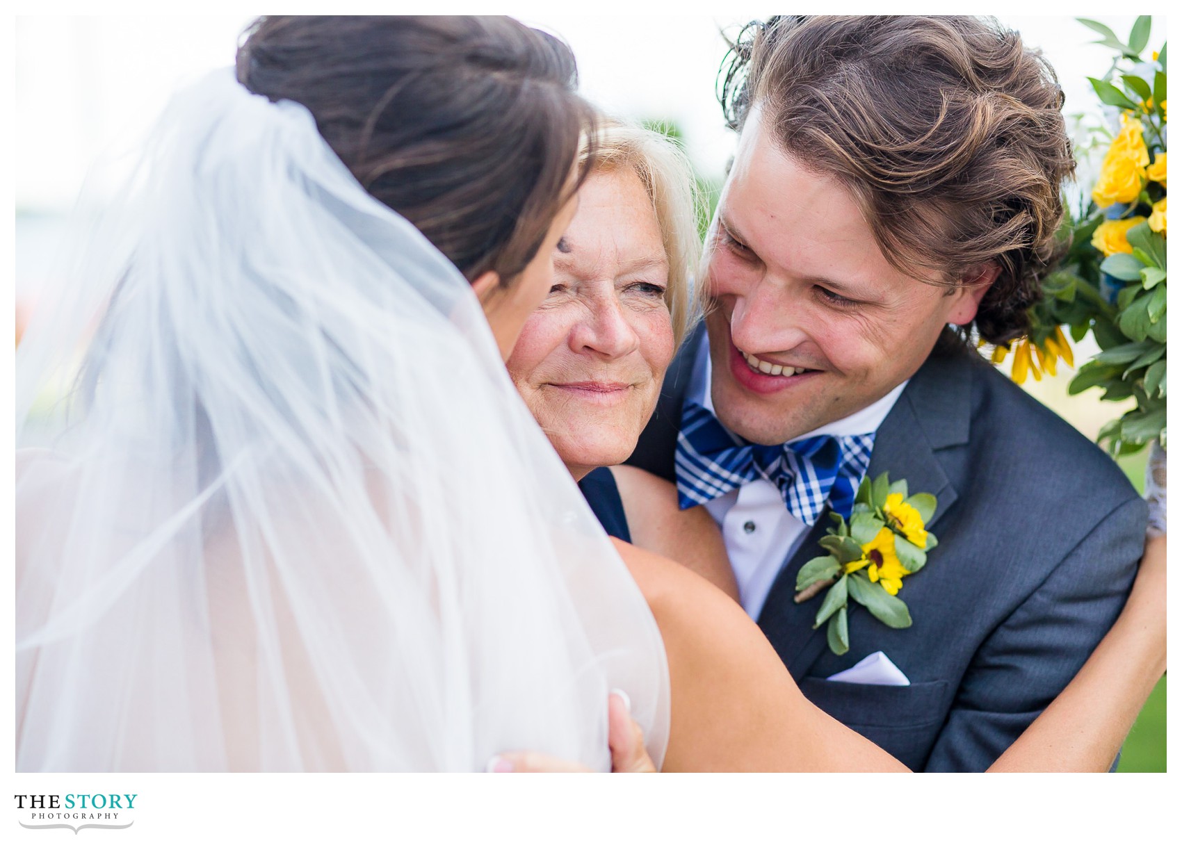 bride and brother hug their mother on wedding day