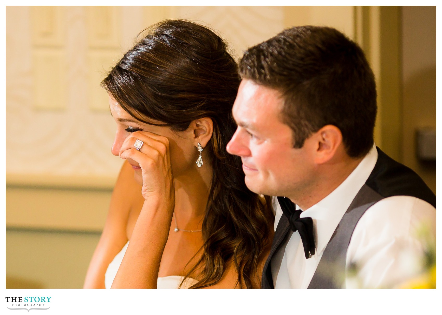 bride wipes a tear from her eye during wedding reception toasts