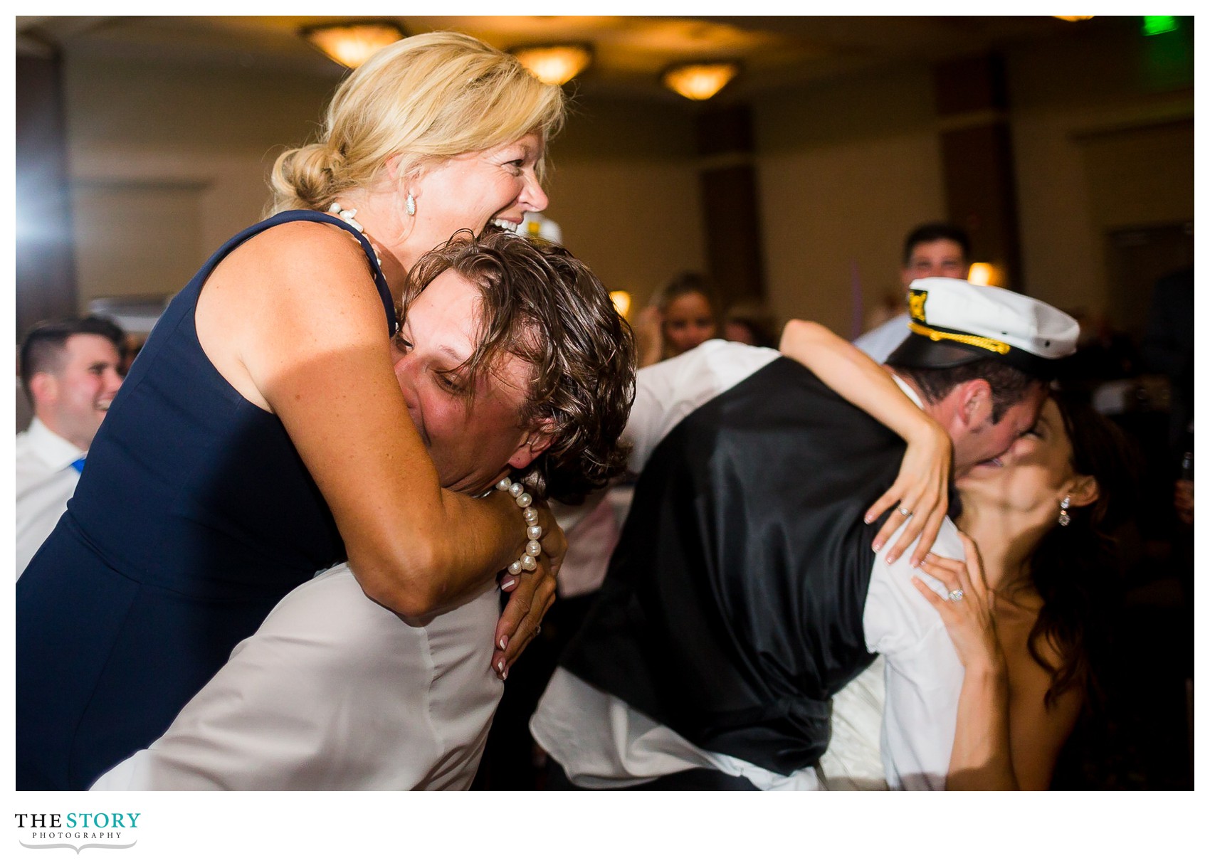 bride's mom gets lifted in the air while groom dips the bride 