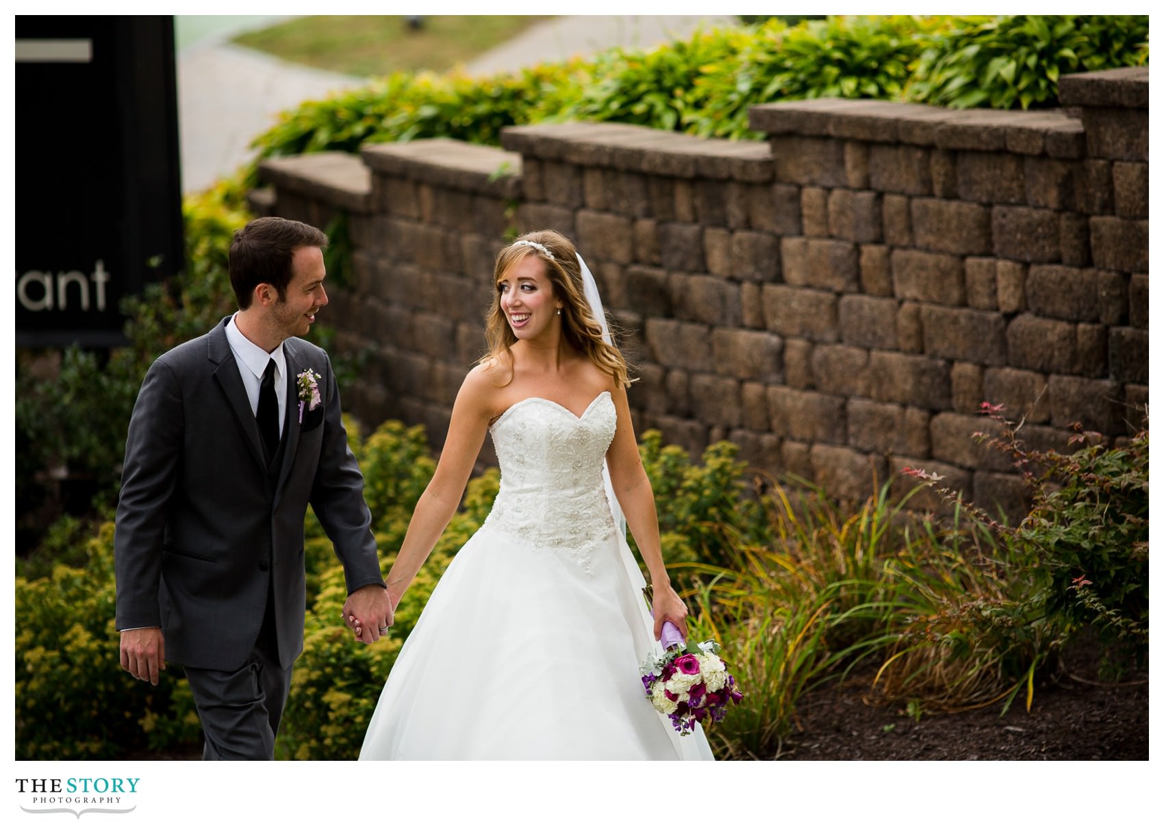 bride and groom walk to Genesee Grande Hotel wedding reception