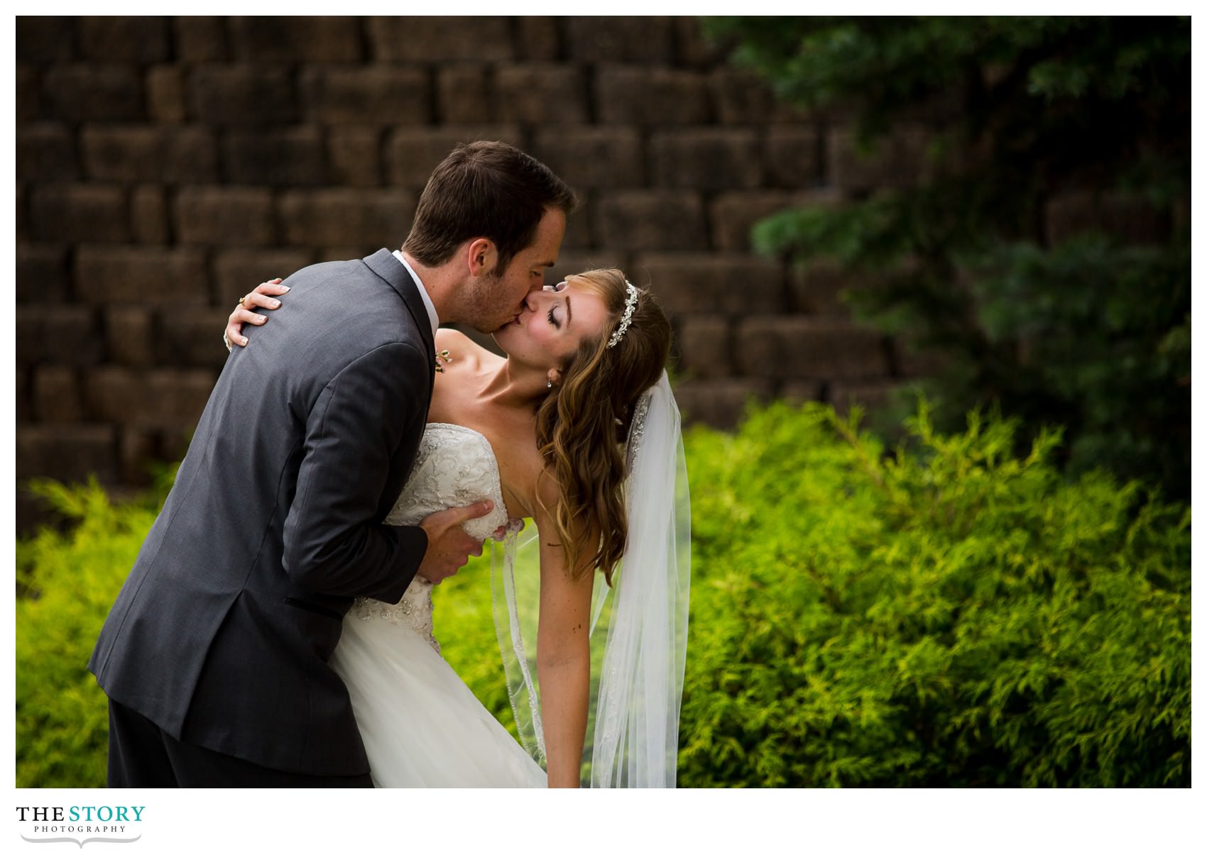 groom gives bride a great kiss outside of Genesee Grande Hotel wedding reception