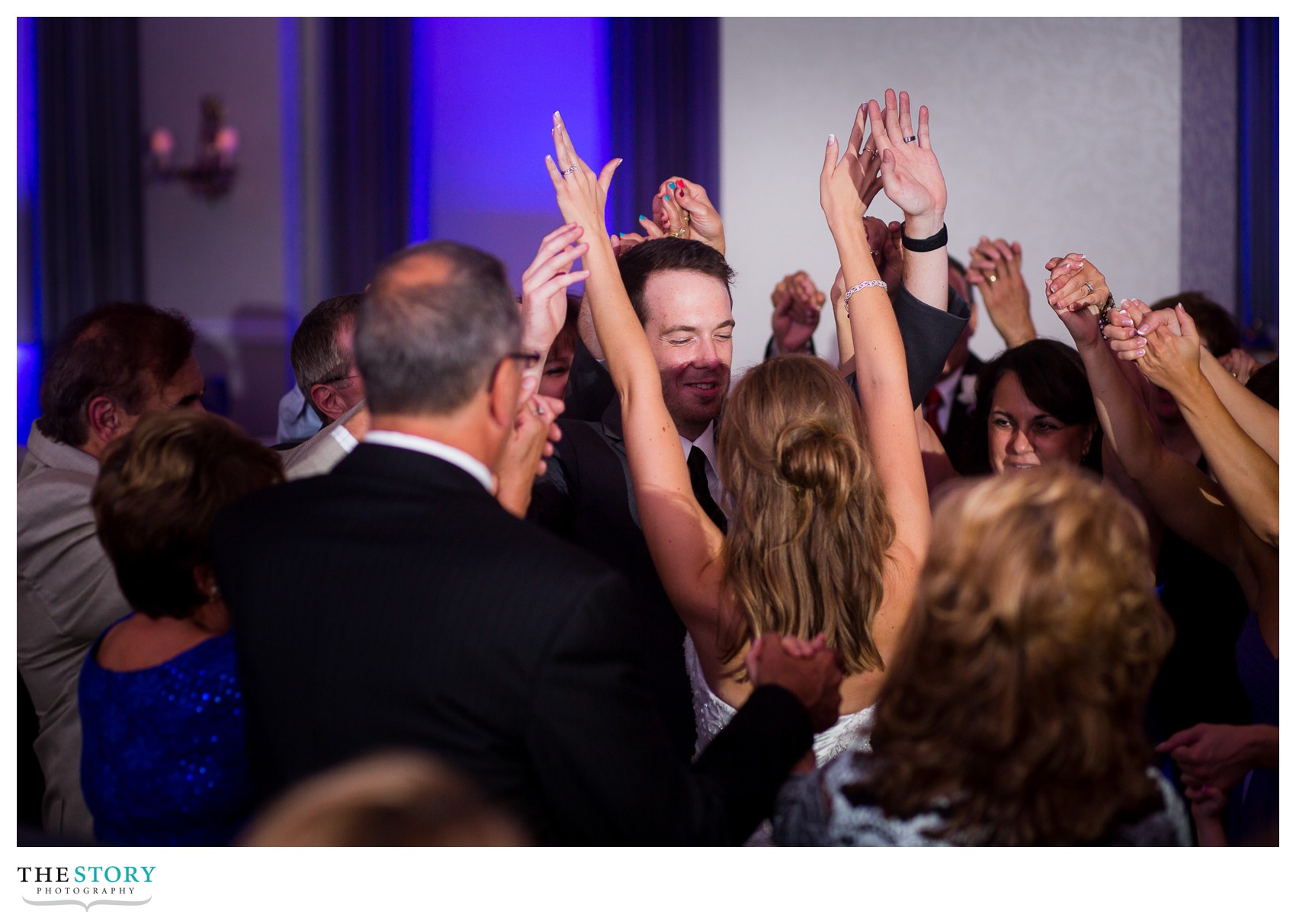 bride and groom surrounded by family and friends at syracuse, ny wedding reception