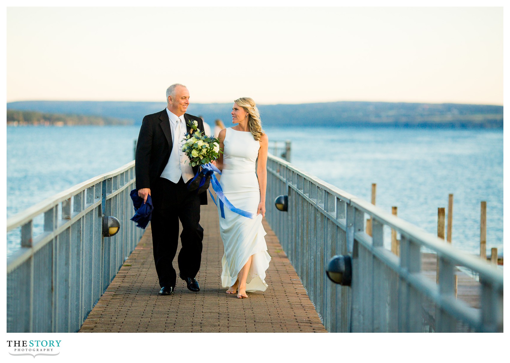 bride and groom walking down Skaneateles pier