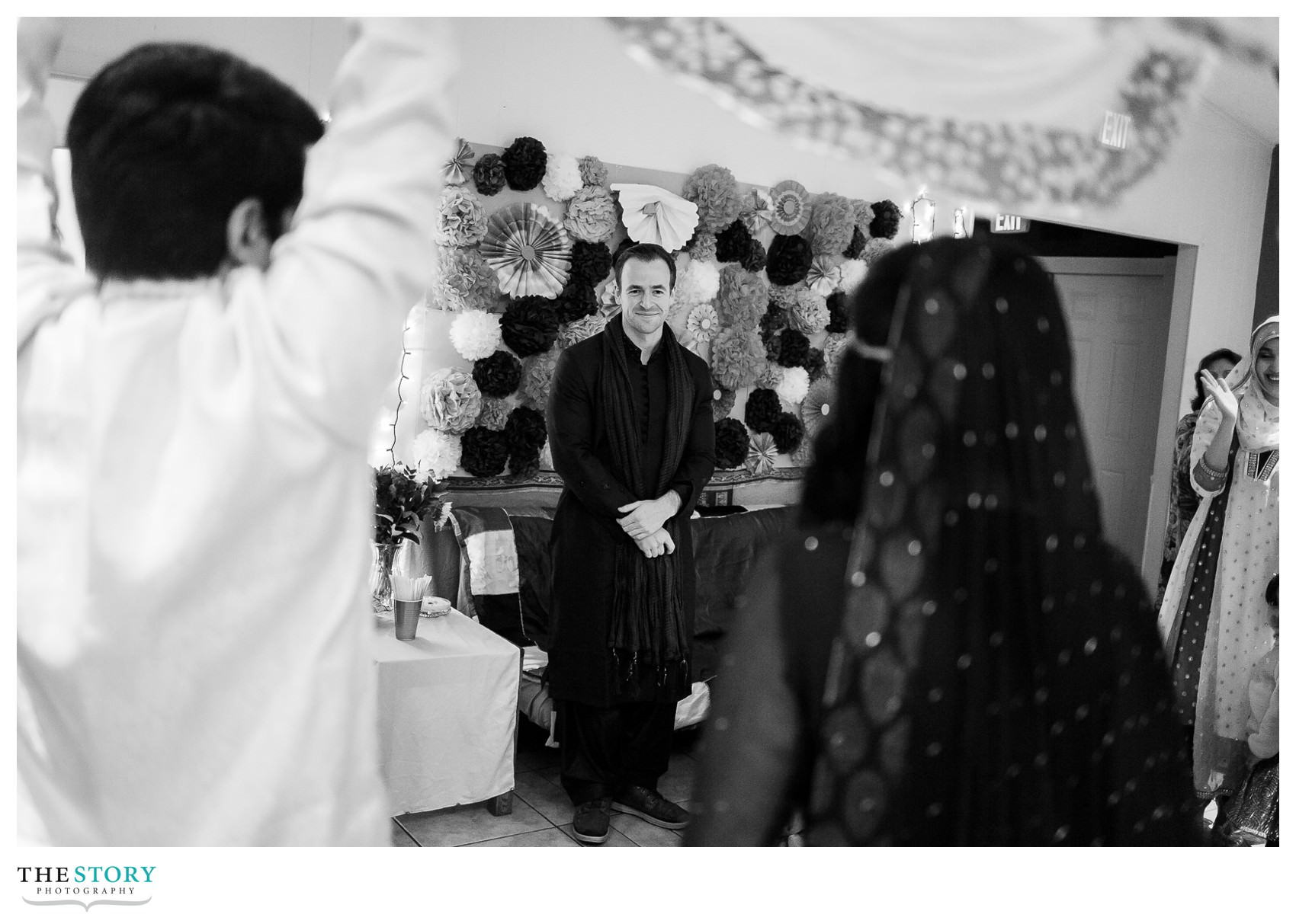 groom watching bride enter the henna celebration the night before the Rochester wedding