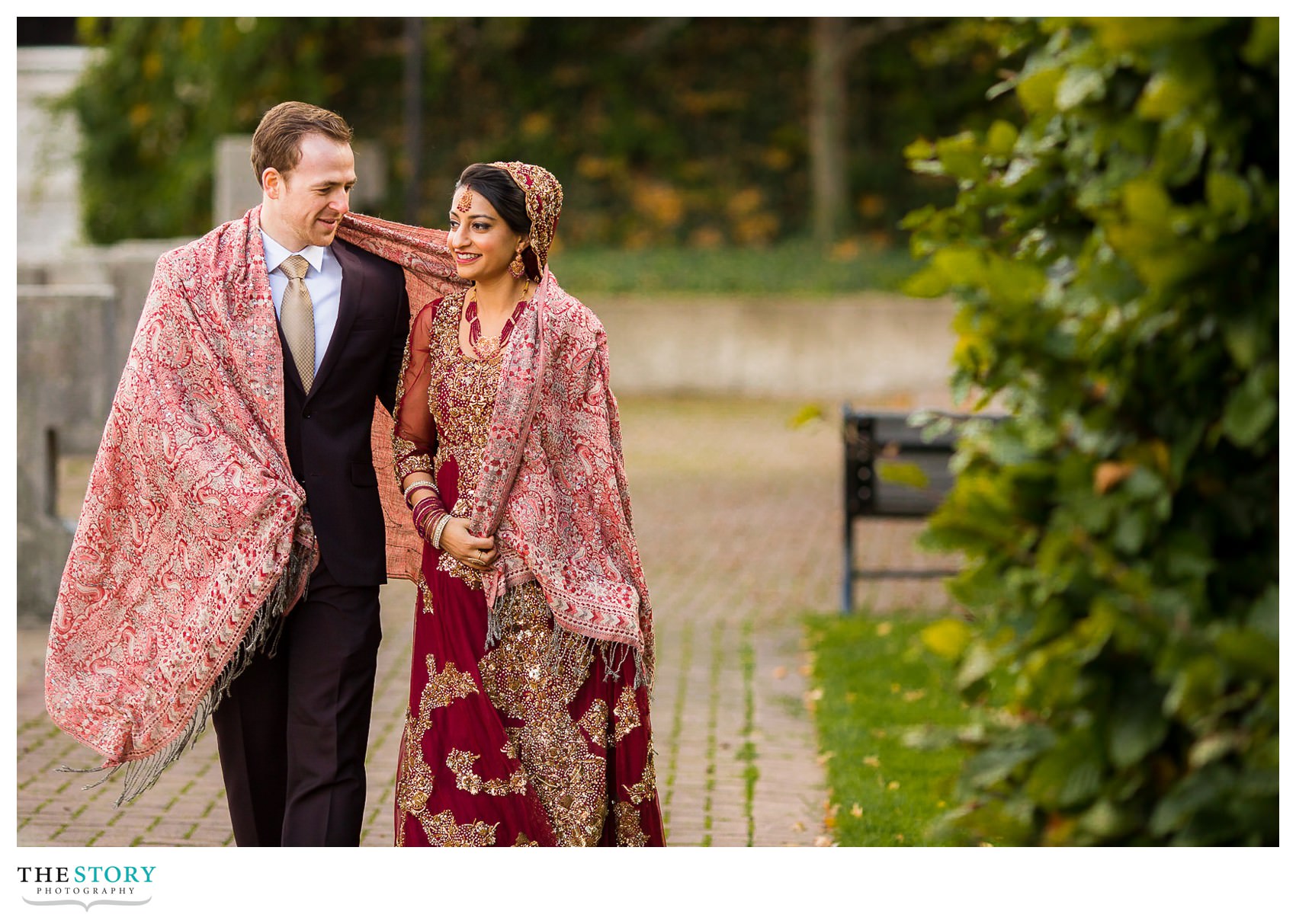 bride and groom walking back to Rochester Radisson Riverside Hotel on a cold fall day