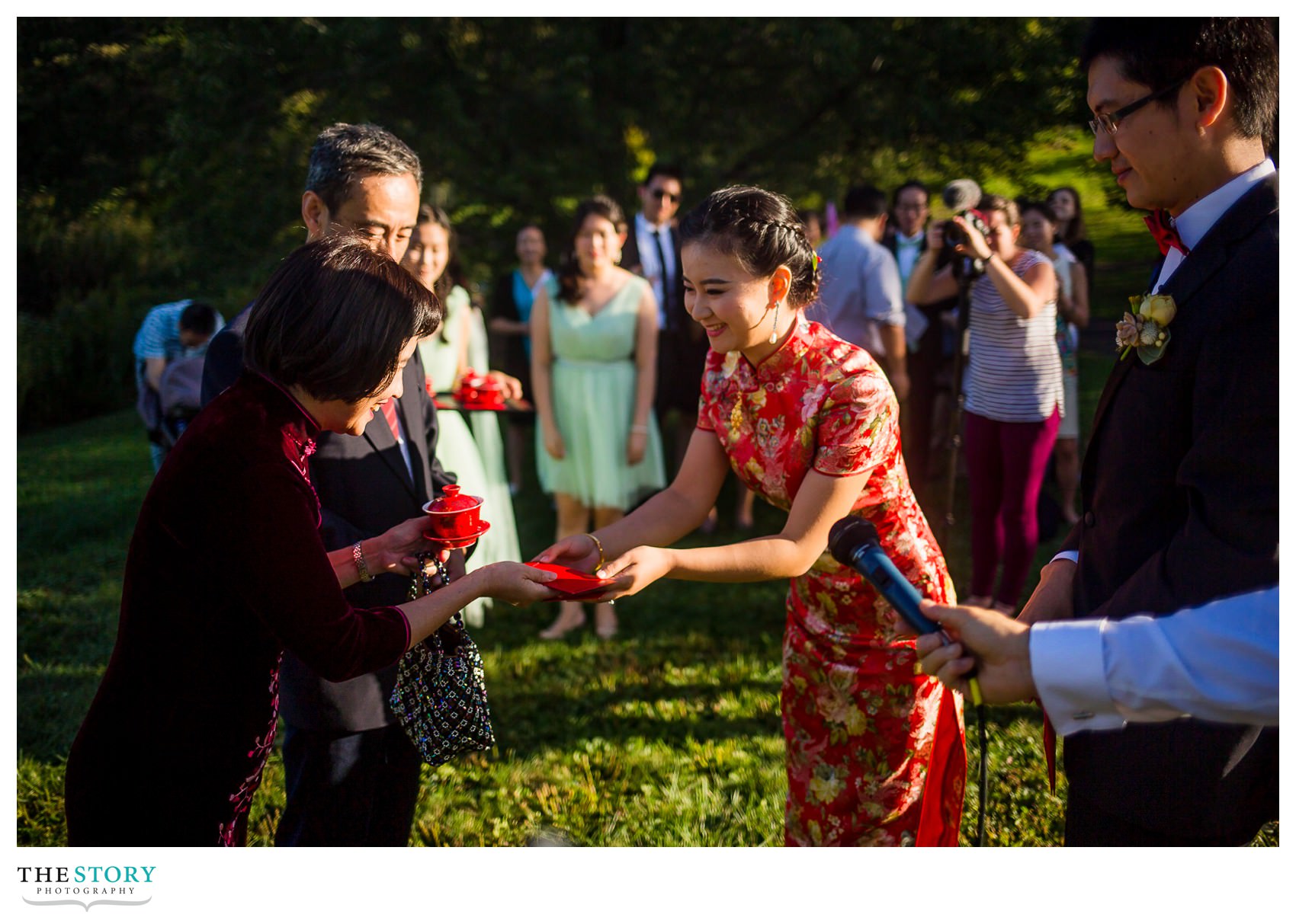 bride serves tea to the groom's mother during Chinese wedding tea ceremony at Cornell Plantations