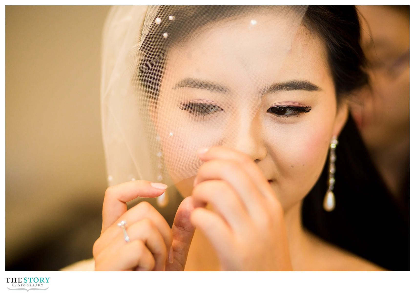 bride adjusts her veil before first look at the A.D White Gardens at Cornell