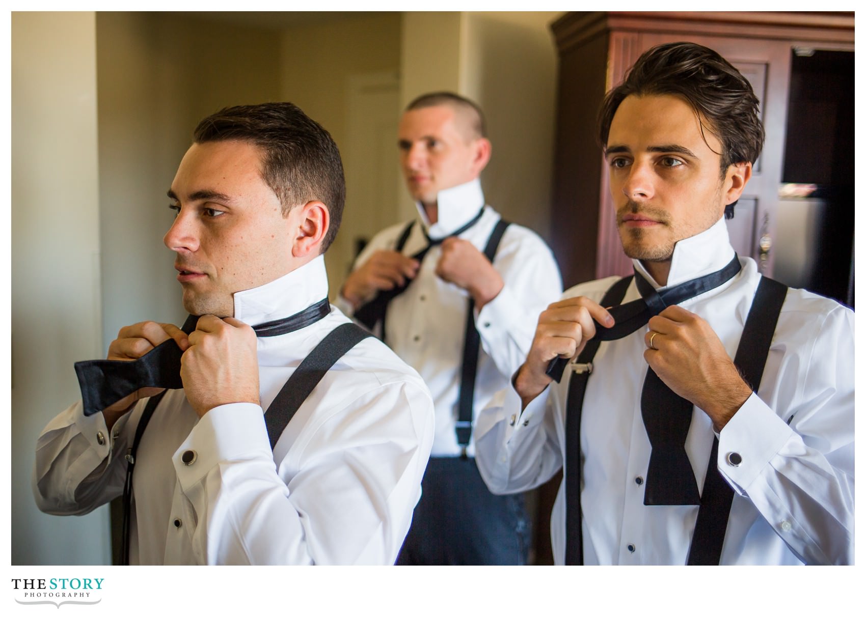 groomsmen tying bowties while getting ready for wedding day