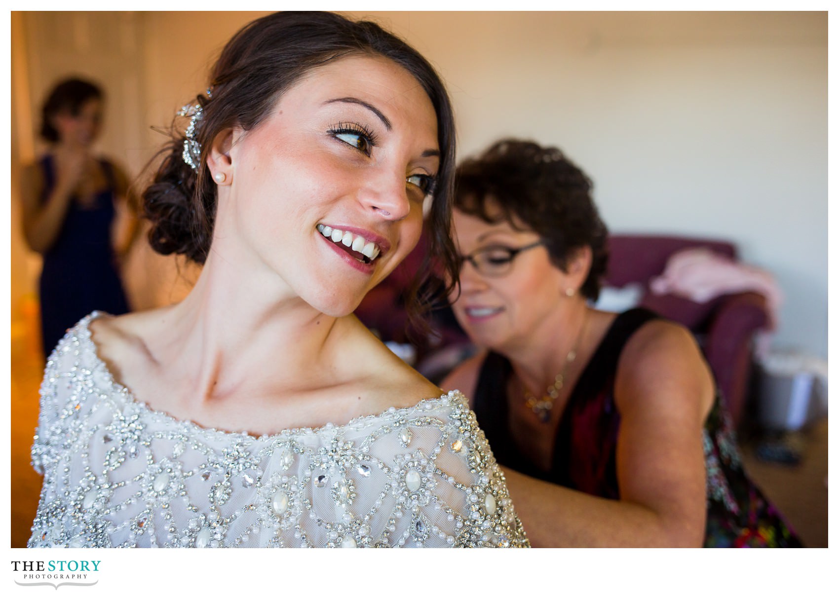 mother helps bride with wedding dress