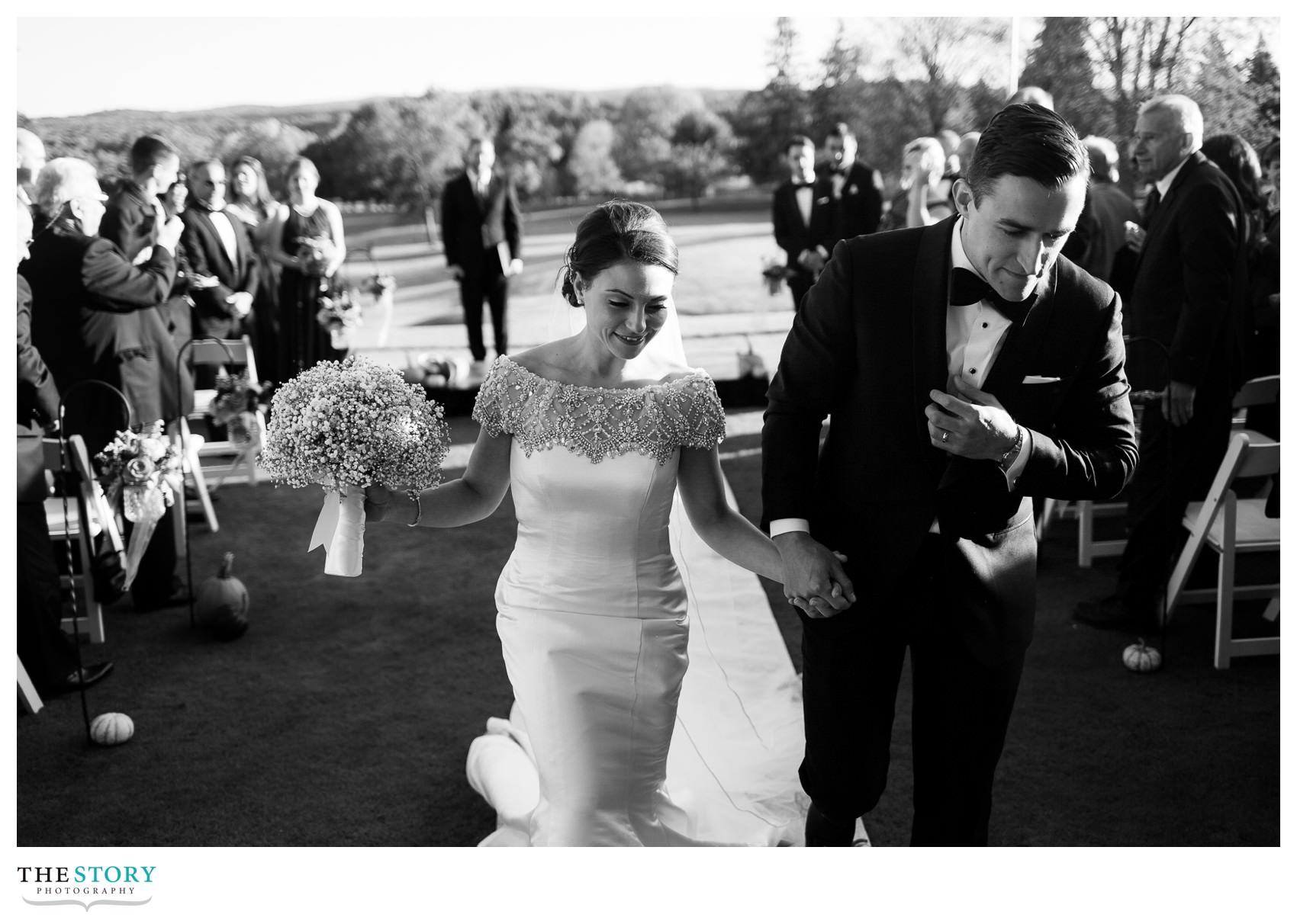 bride and groom leave outdoor wedding ceremony at Onondaga Country Club