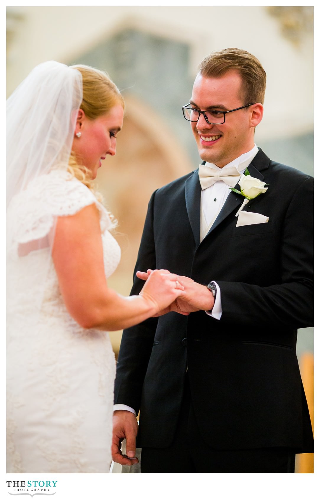 bride places ring on groom's hand during Syracuse wedding ceremony