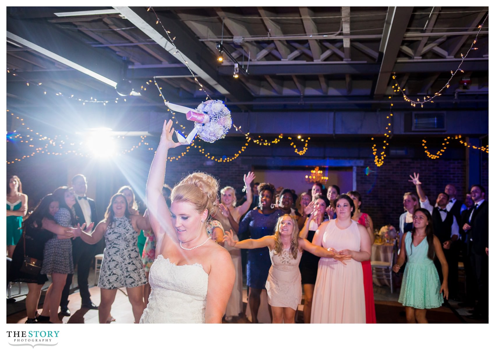 bride tosses bouquet at Sky Armory wedding reception