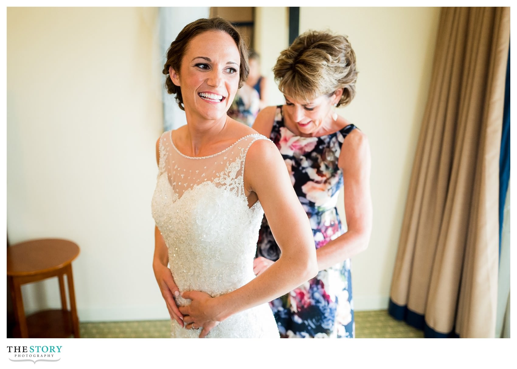 mother of bride helps with getting the dress on