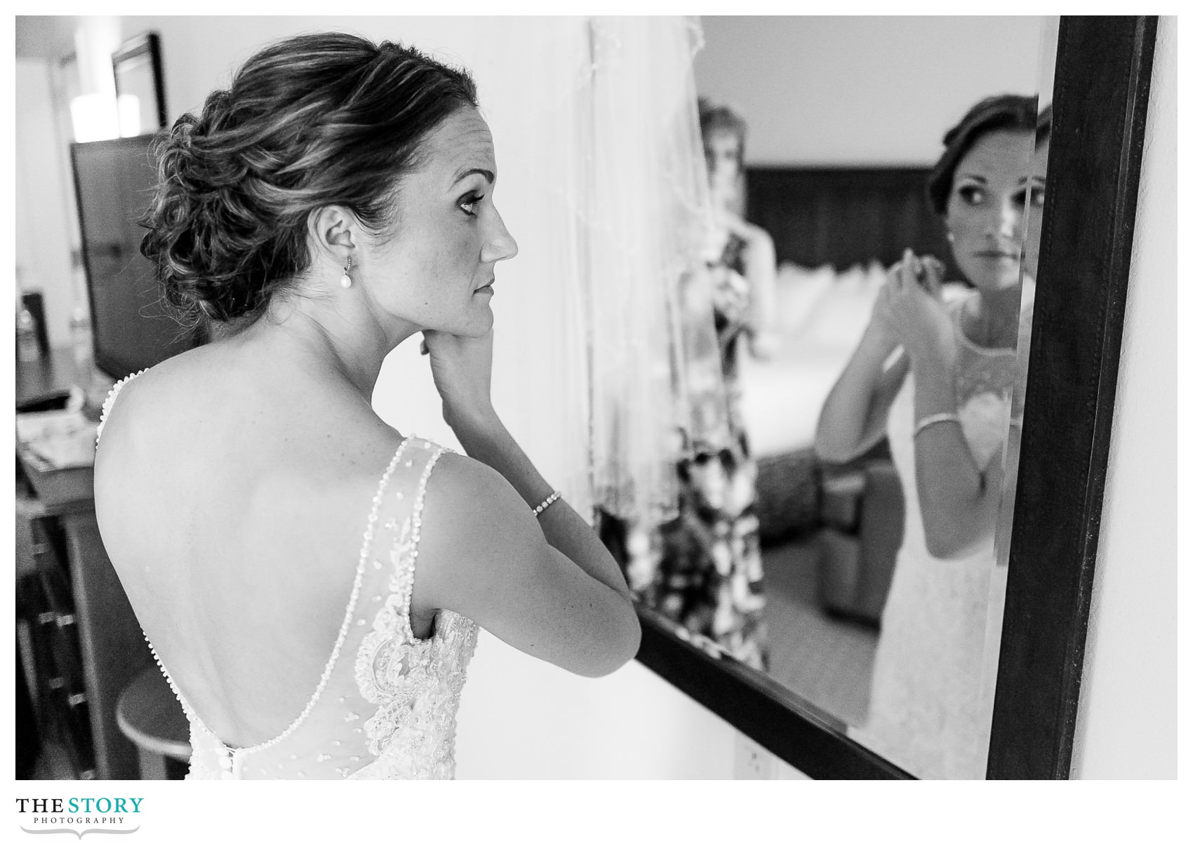 bride putting on earrings as the final touch