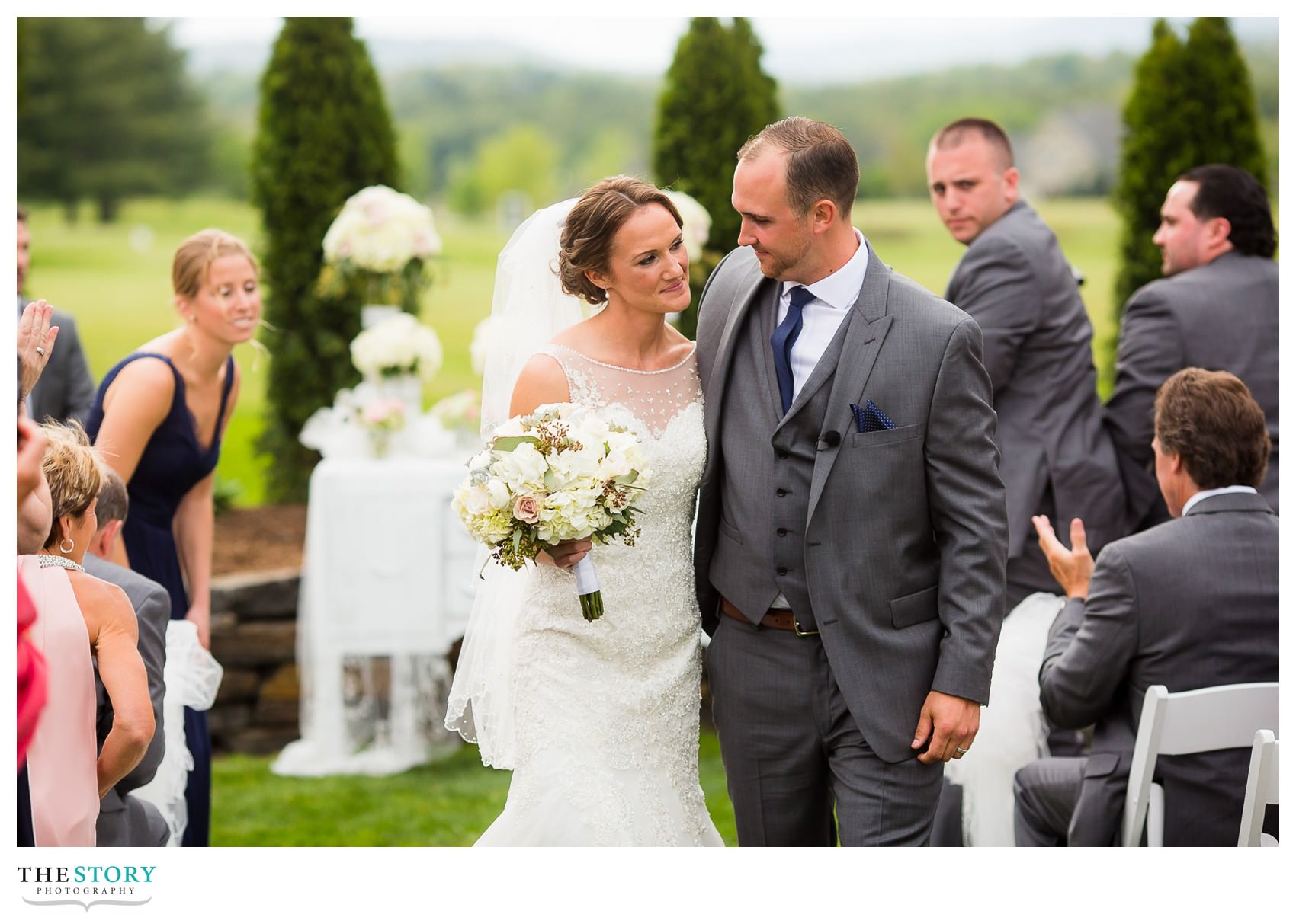 bride and groom enjoy a little moment of their own as the leave the wedding ceremony together