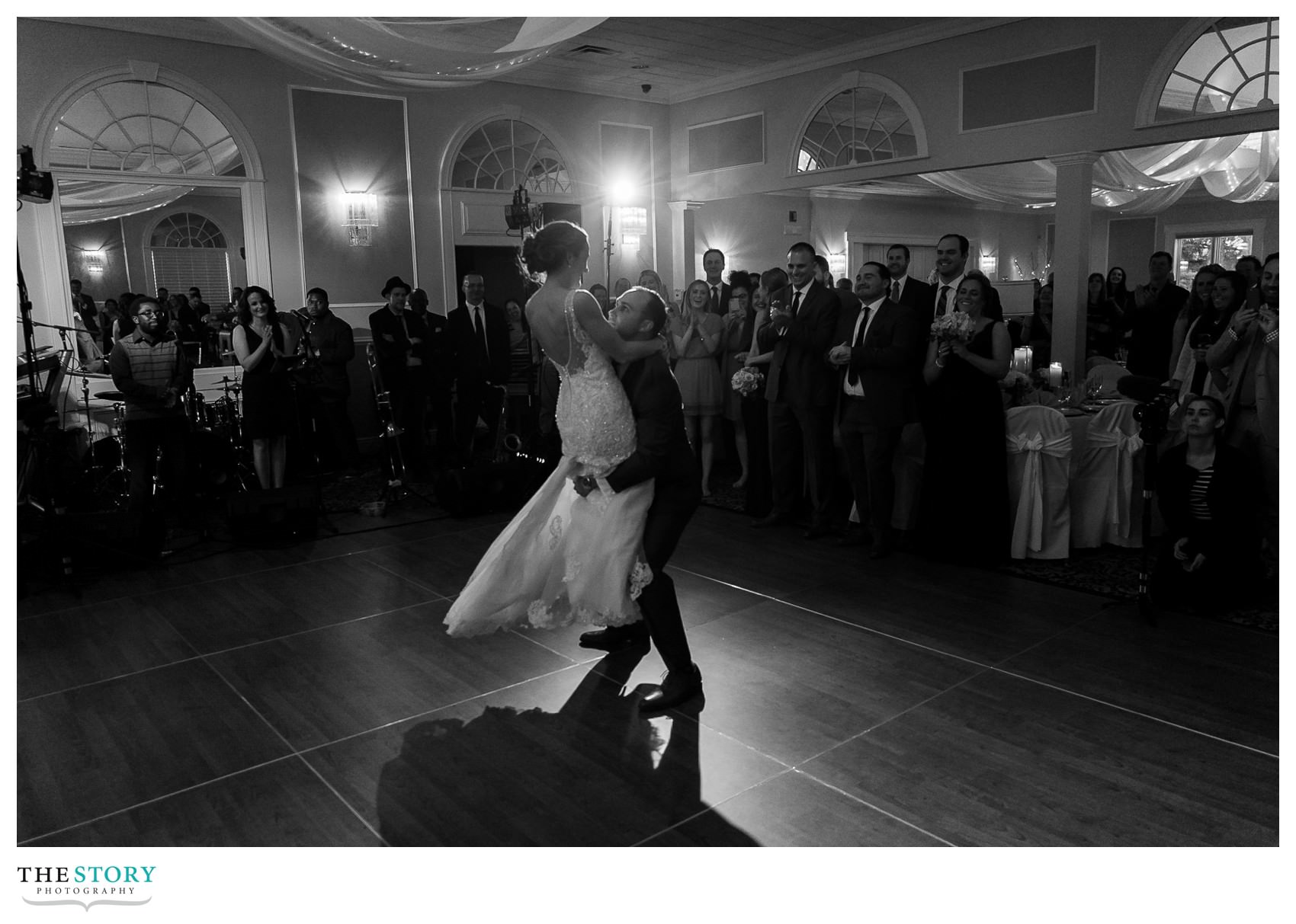 groom lifts bride during choreographed first dance at wedding reception