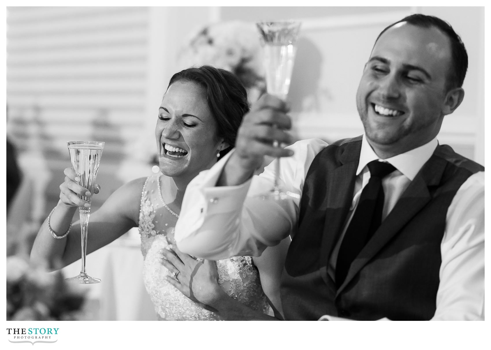 bride and groom laugh during toasts