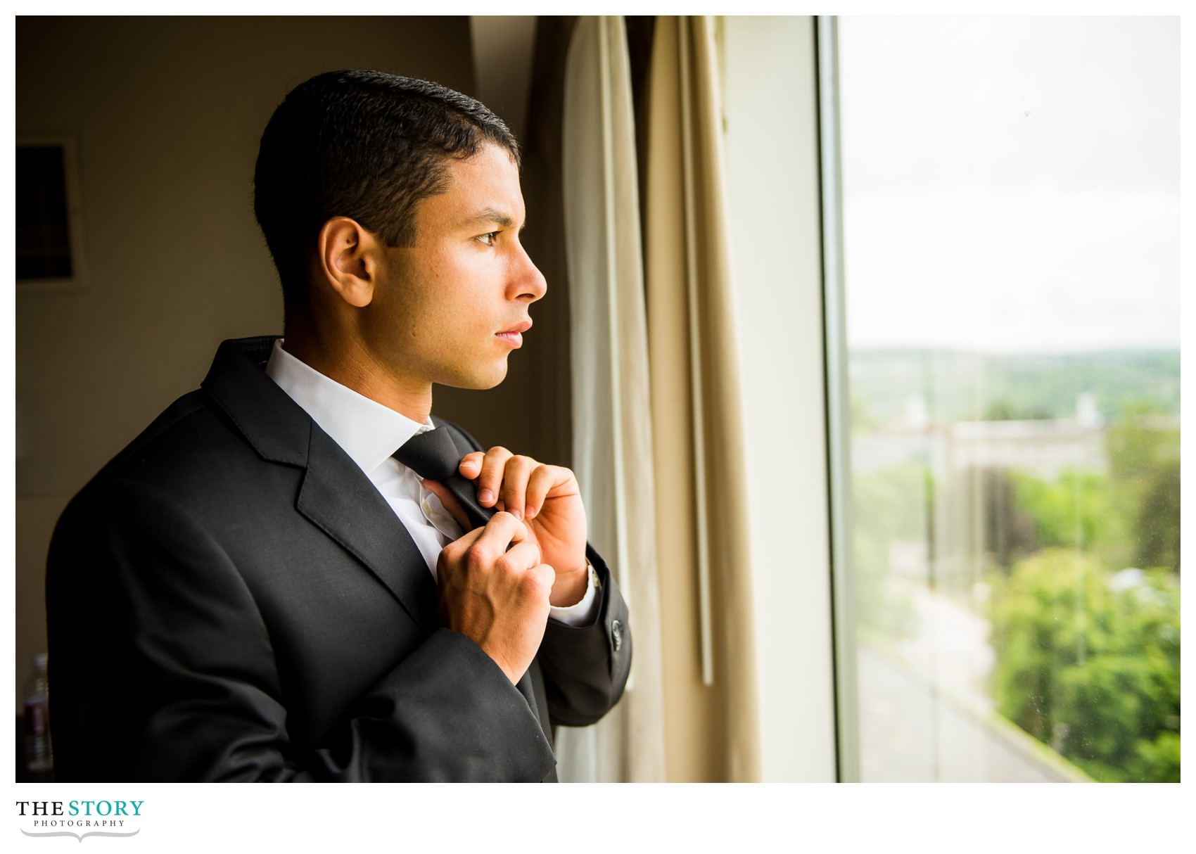 groom adjusts his tie at Cornell's Statler Hotel