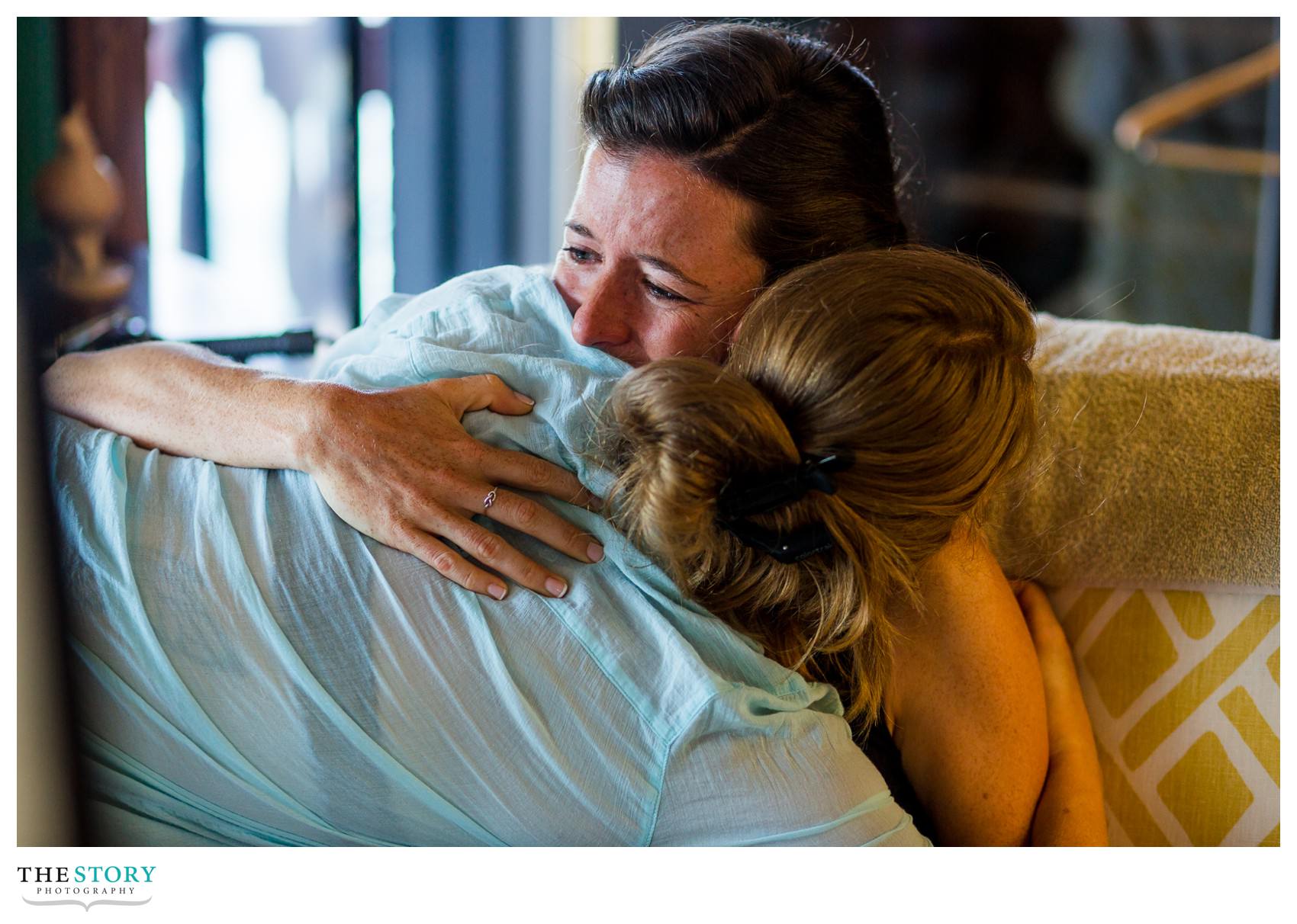 bride and friend hugging before wedding at Antique Boat Museum in Clayton, NY