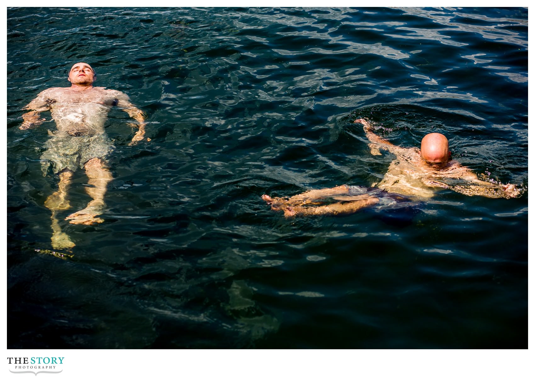 groom swimming in river before wedding at Antique Boat Museum