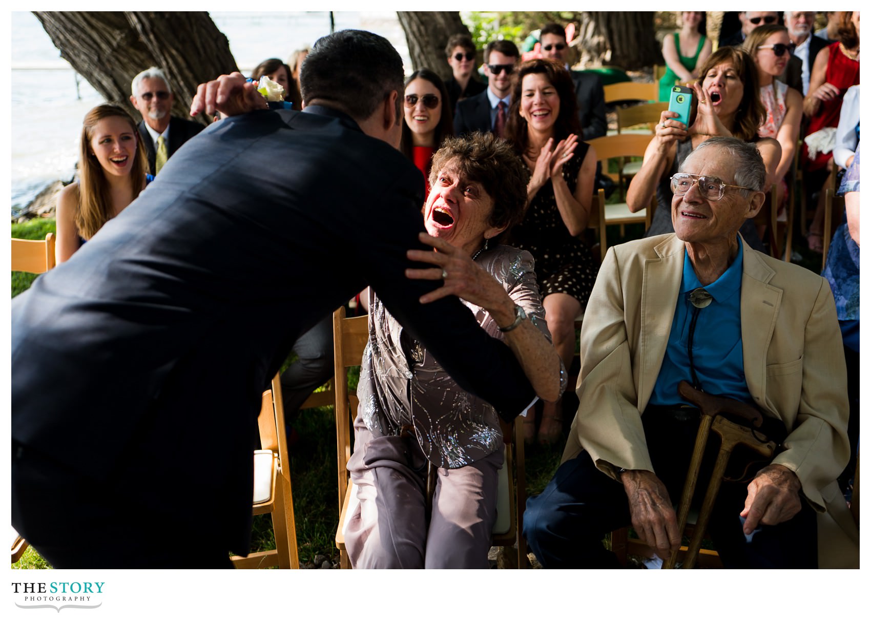 groom hugs grandmother at outdoor wedding ceremony