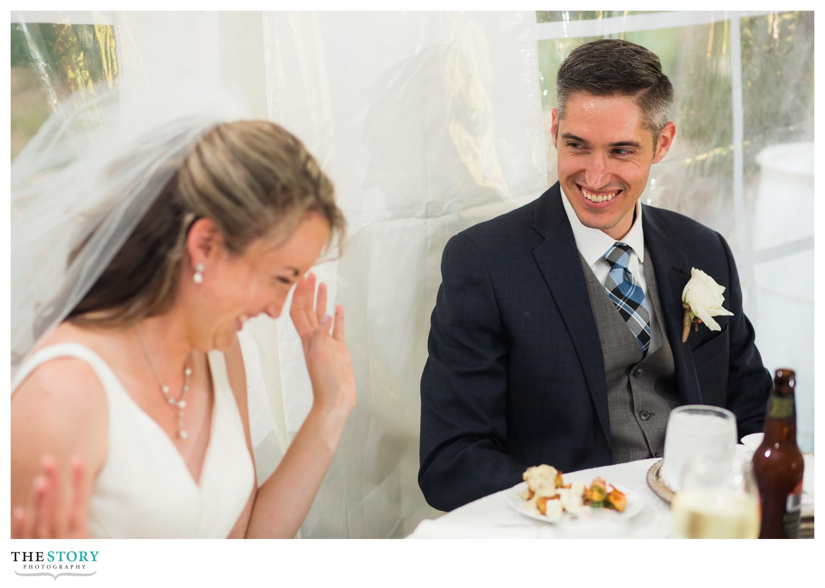 bride and groom react to speech at wedding reception