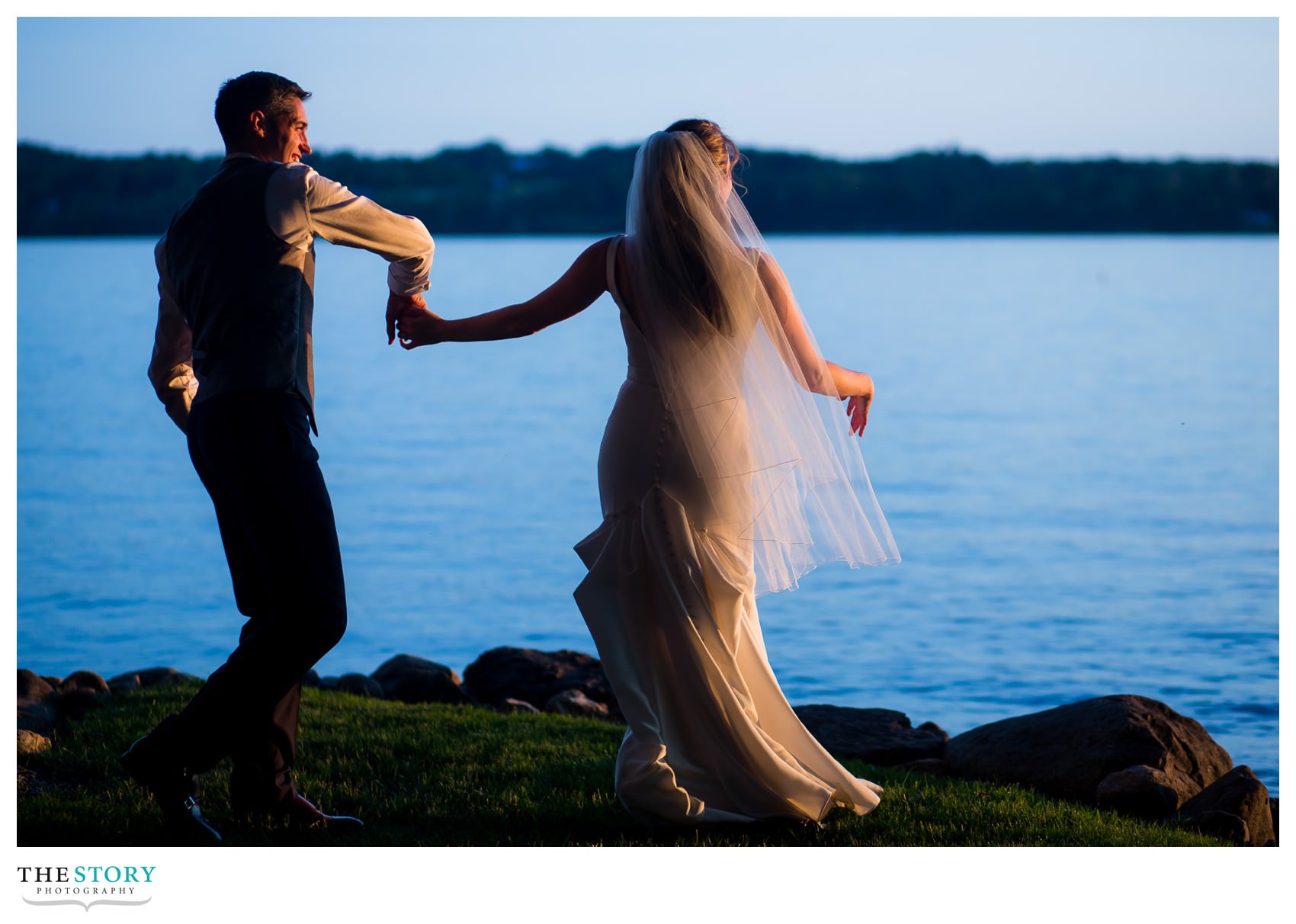 bride and groom dance on the shore of Skaneateles Lake