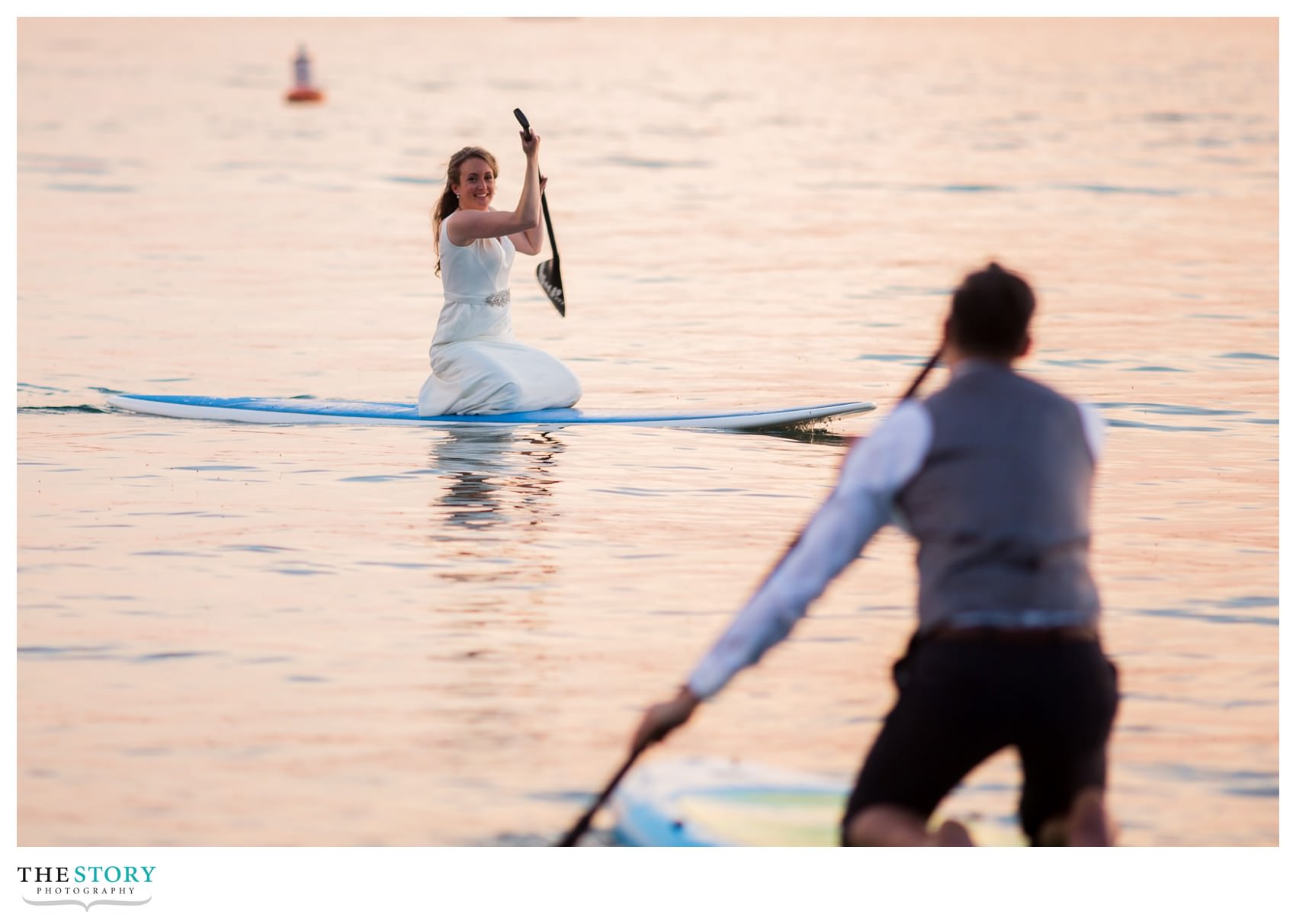bride and groom paddle board on Skaneateles Lake