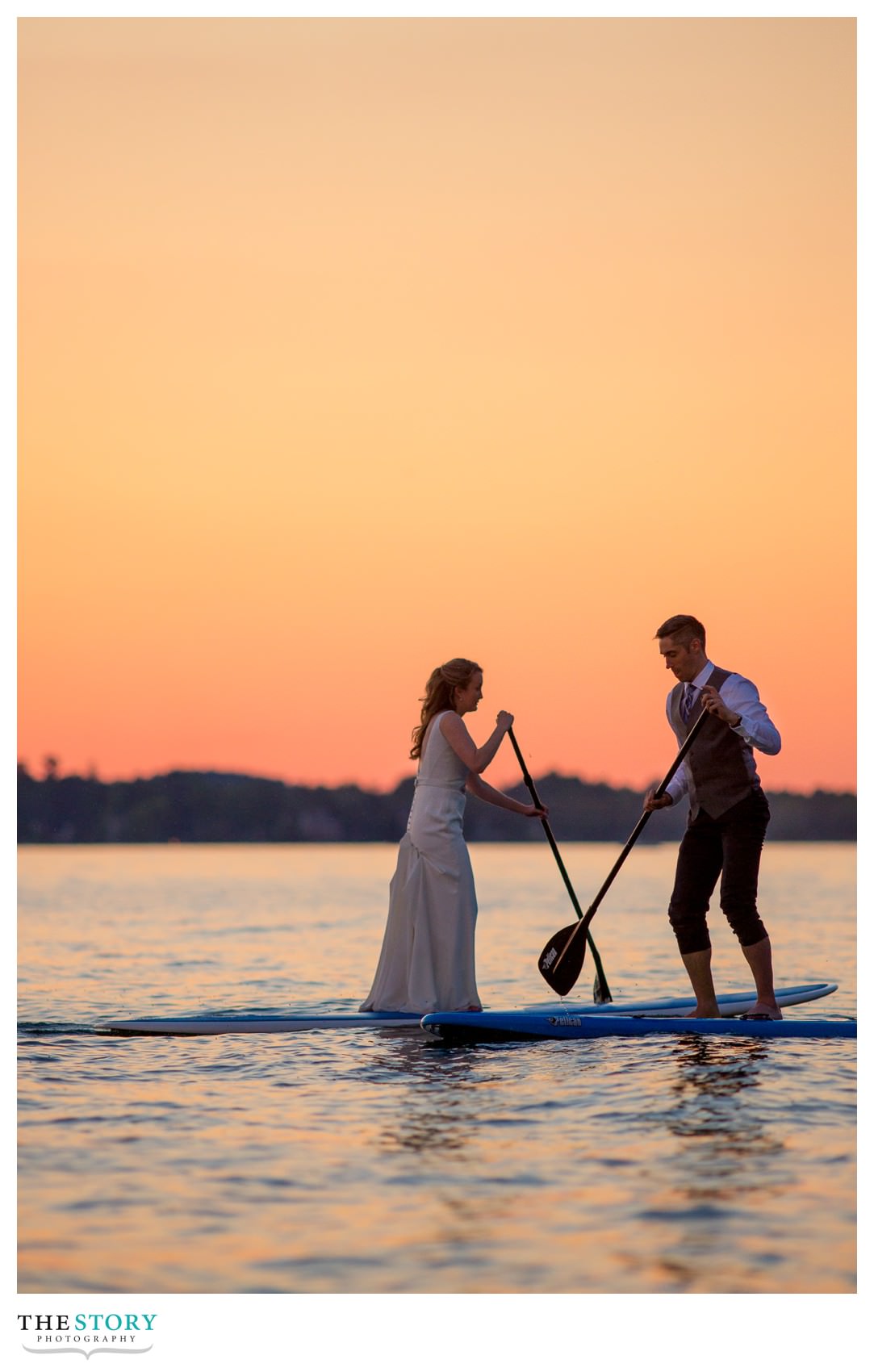 wedding day paddle boarding on Skaneateles Lake at sunset