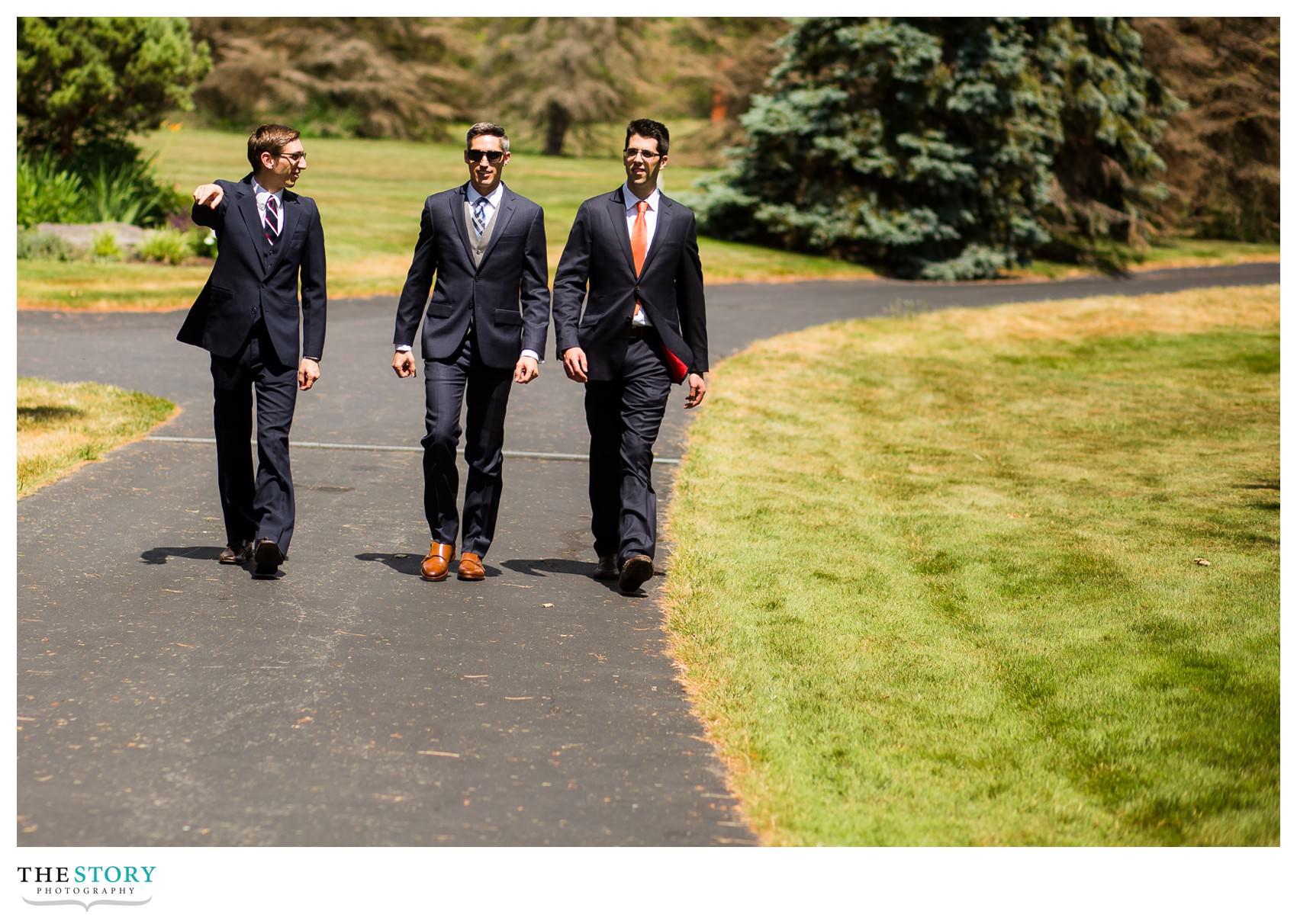 groom and groomsmen walking to wedding on Skaneateles Lake