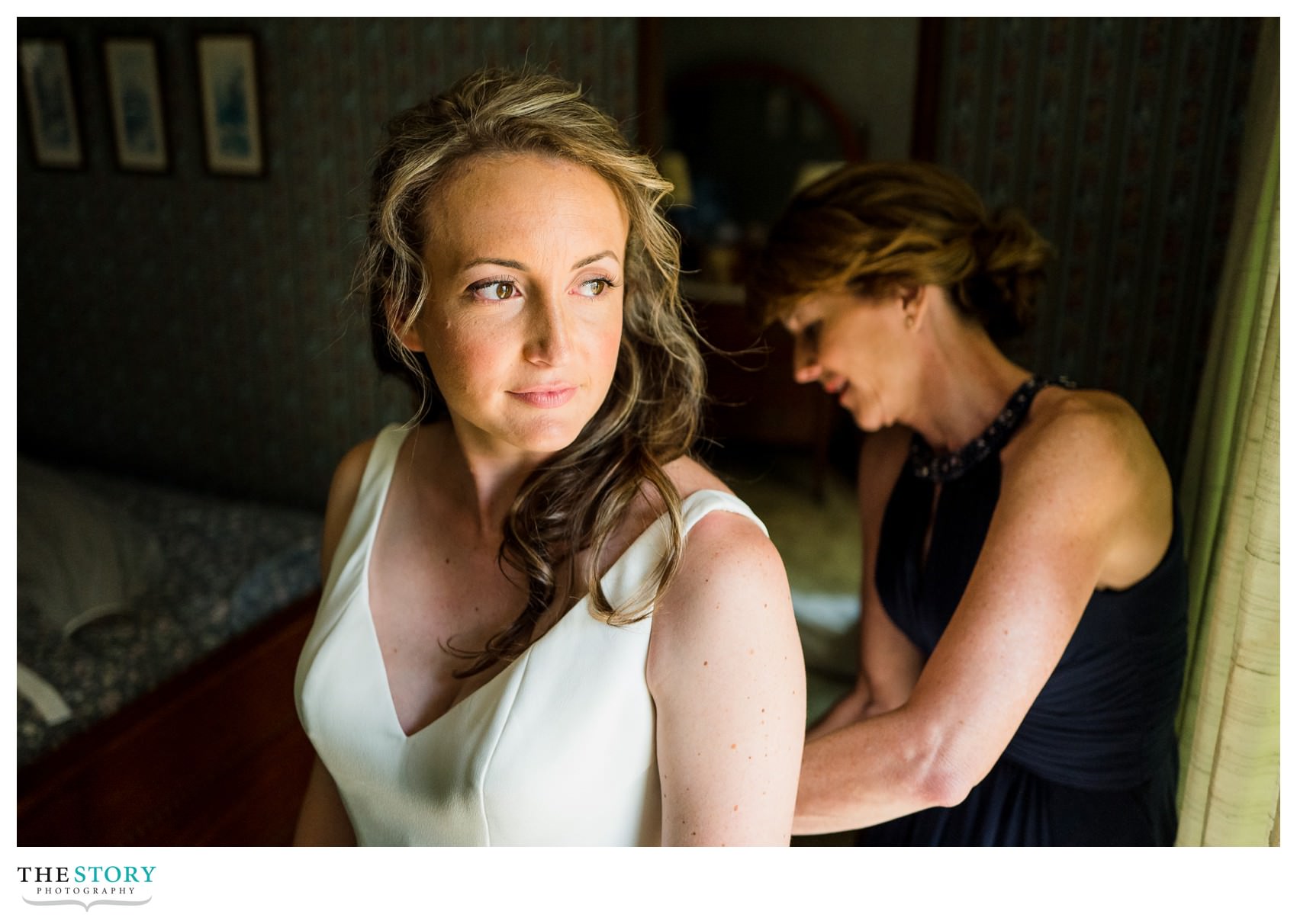 bride getting wedding dress on at Skaneateles Lake house wedding