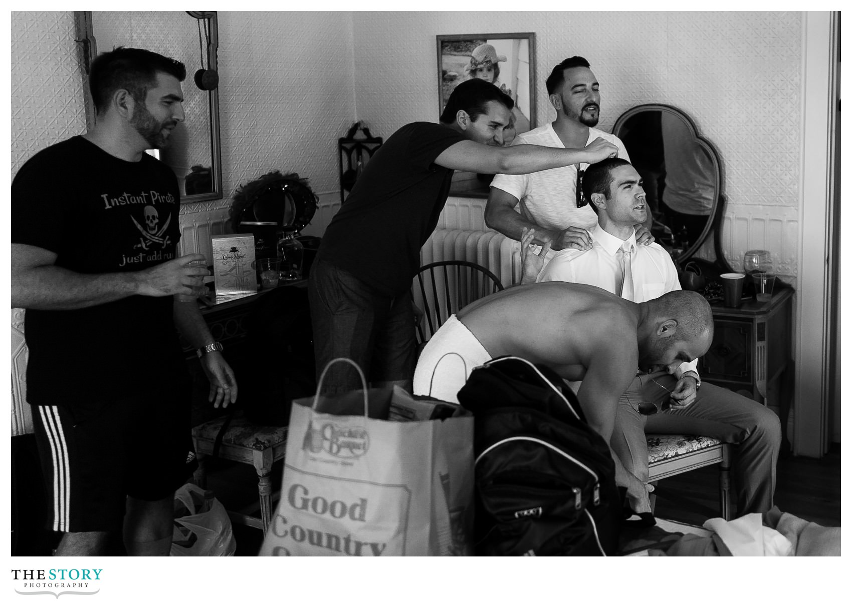 groomsmen taking care of the groom on the wedding day at casa blanca cherry island