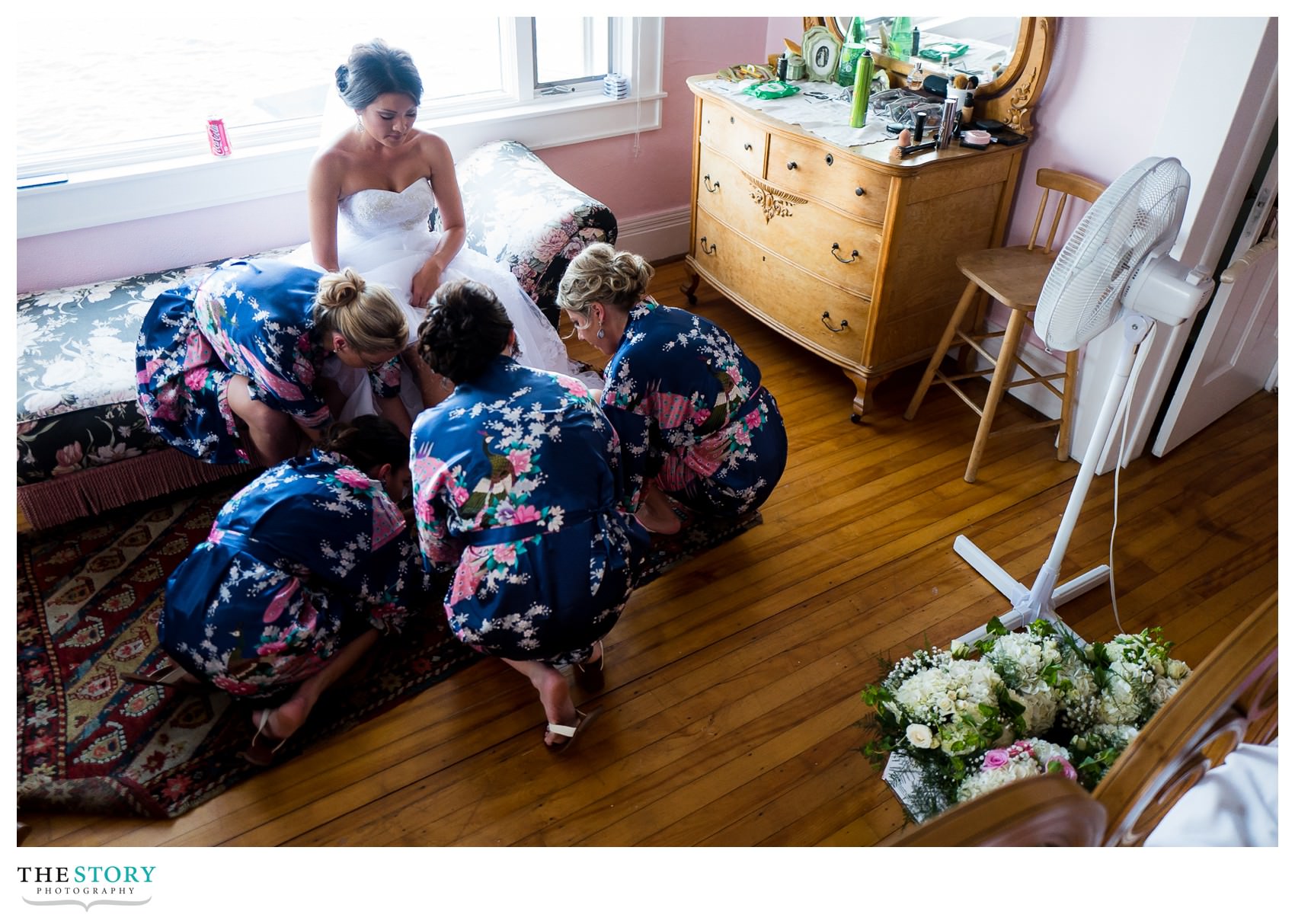 bridesmaids help bride with shoes