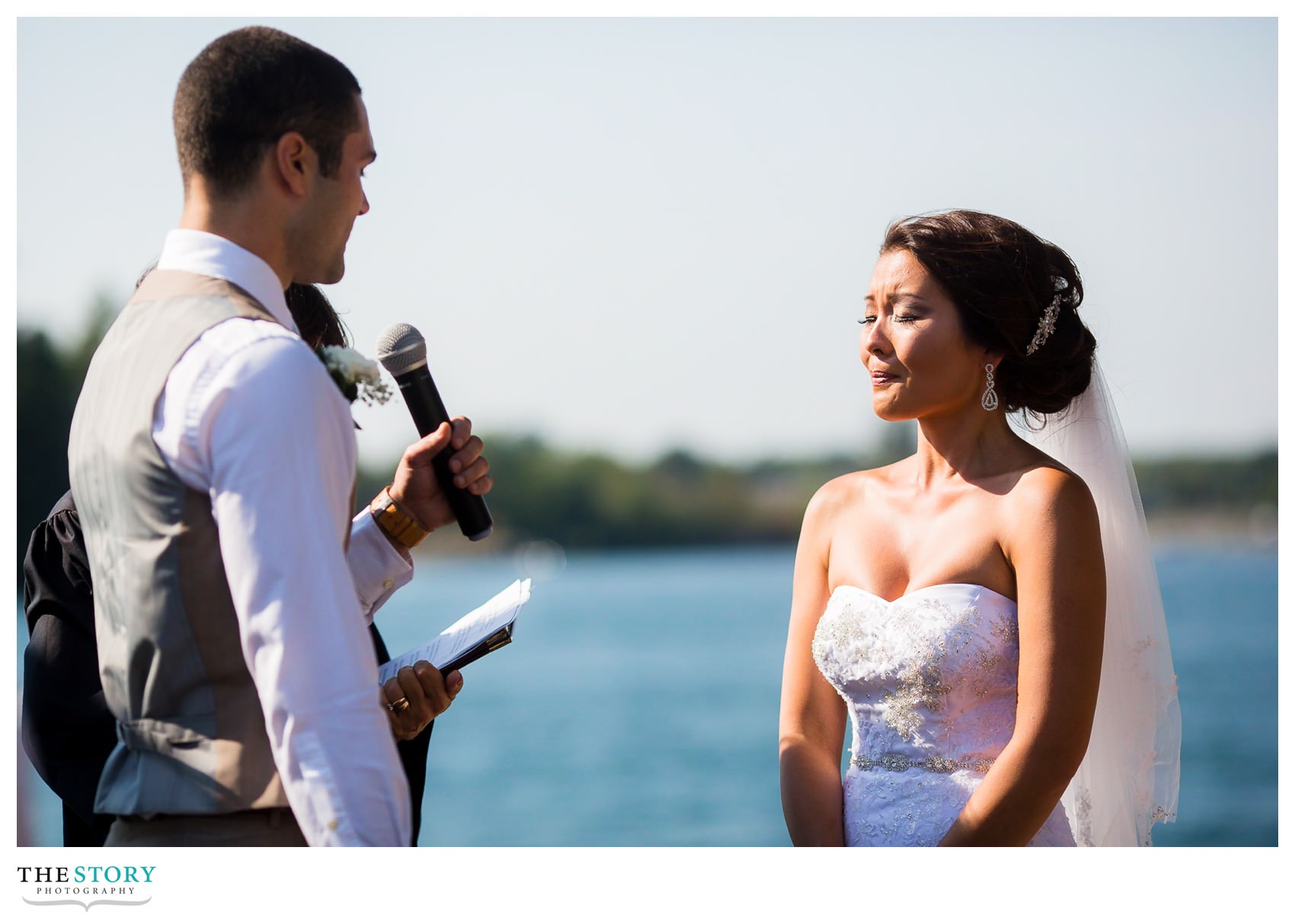 bride holds back tears as groom says his vows at cherry island wedding