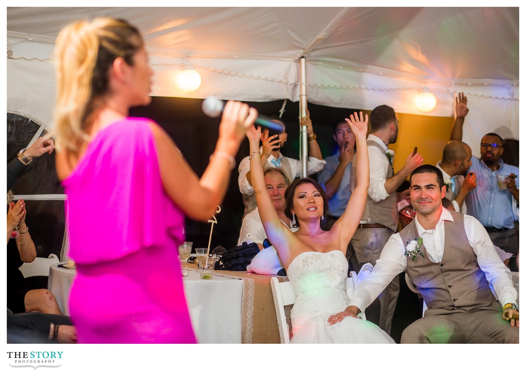 bride and groom enjoy a wedding guest singing for them