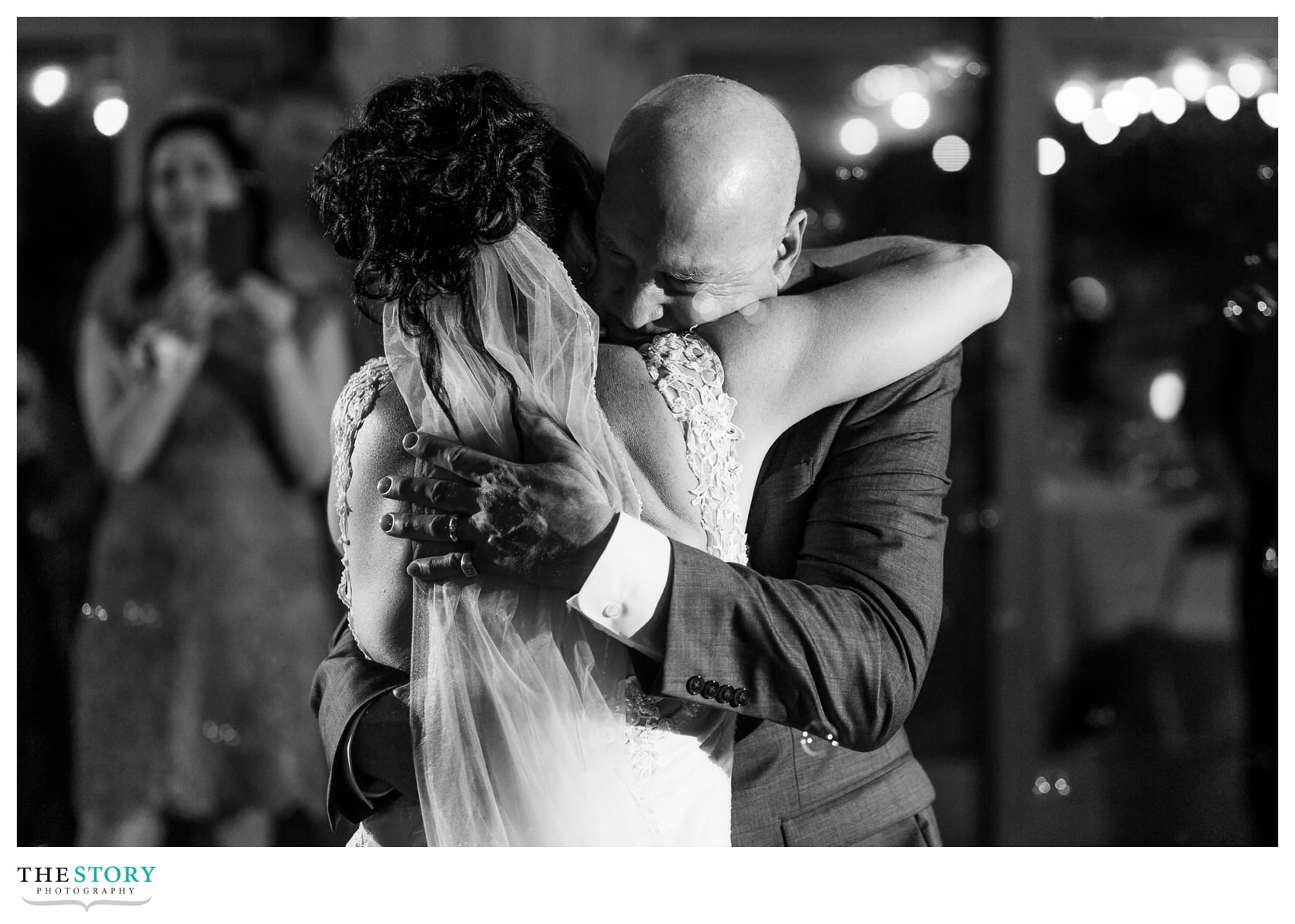 father hugs daughter at wedding reception