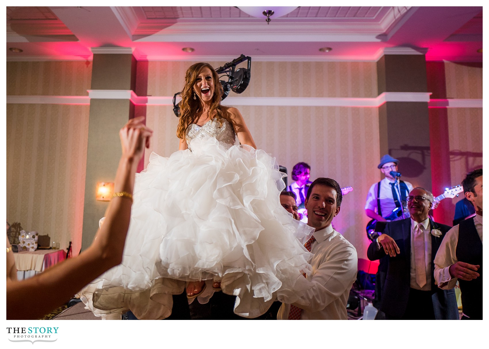 bride is lifted on chair at Watkins Glen wedding reception