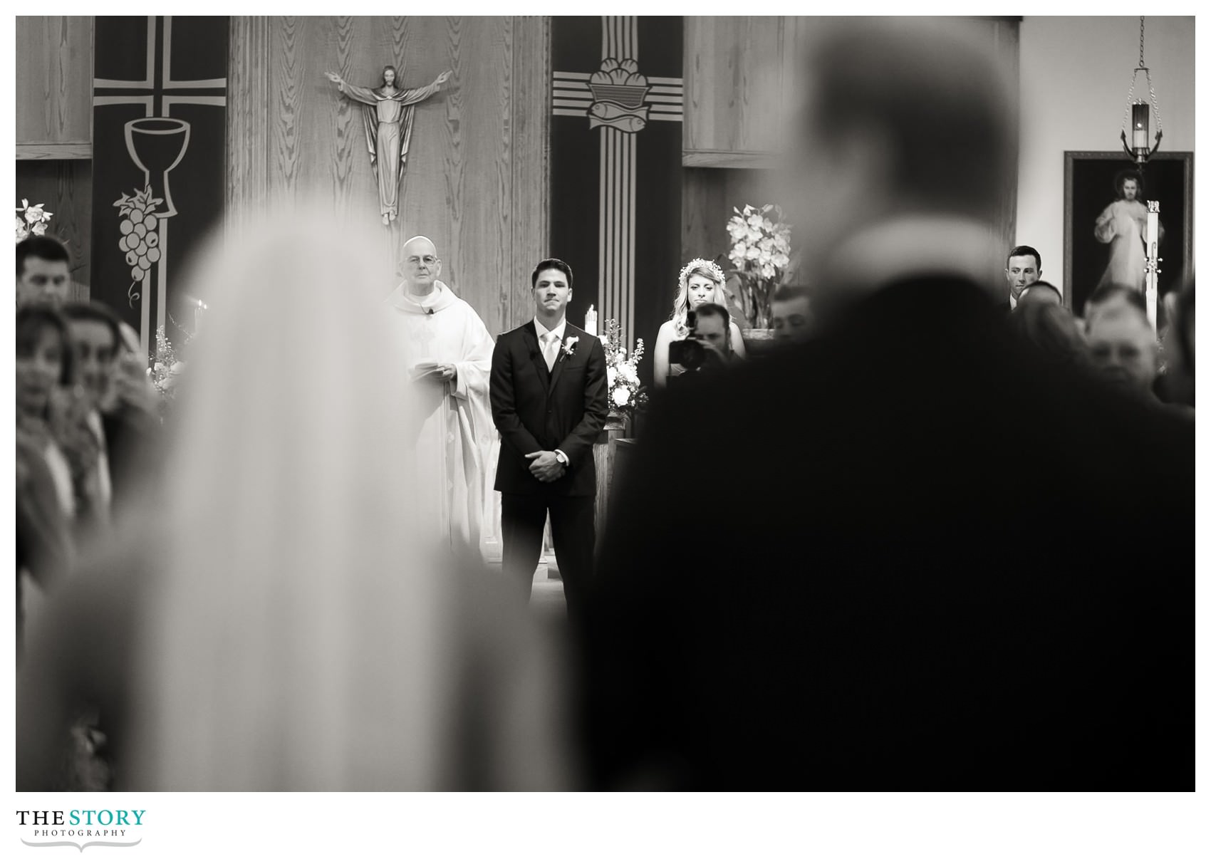 Groom watches bride and her father walk in to wedding ceremony